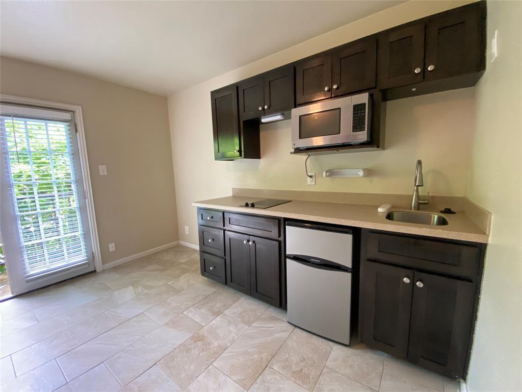 Compact kitchen area featuring dark wood-finish c