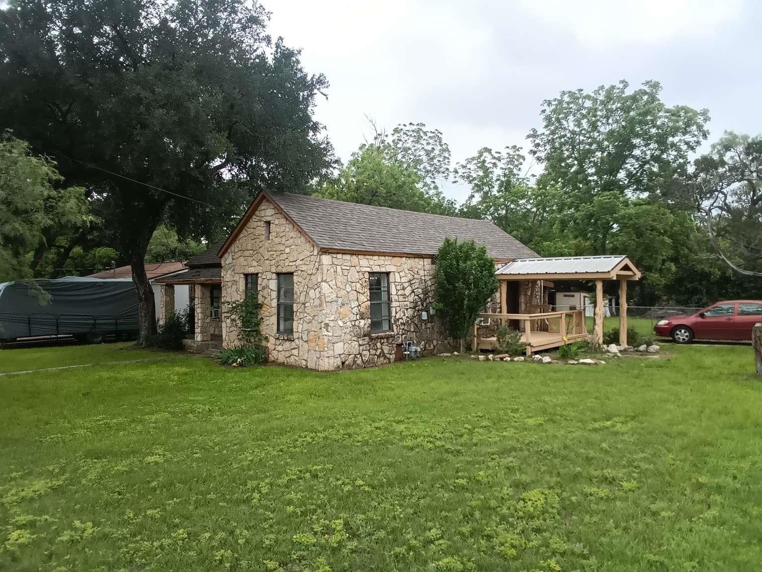 Stone exterior residence featuring a covered fron