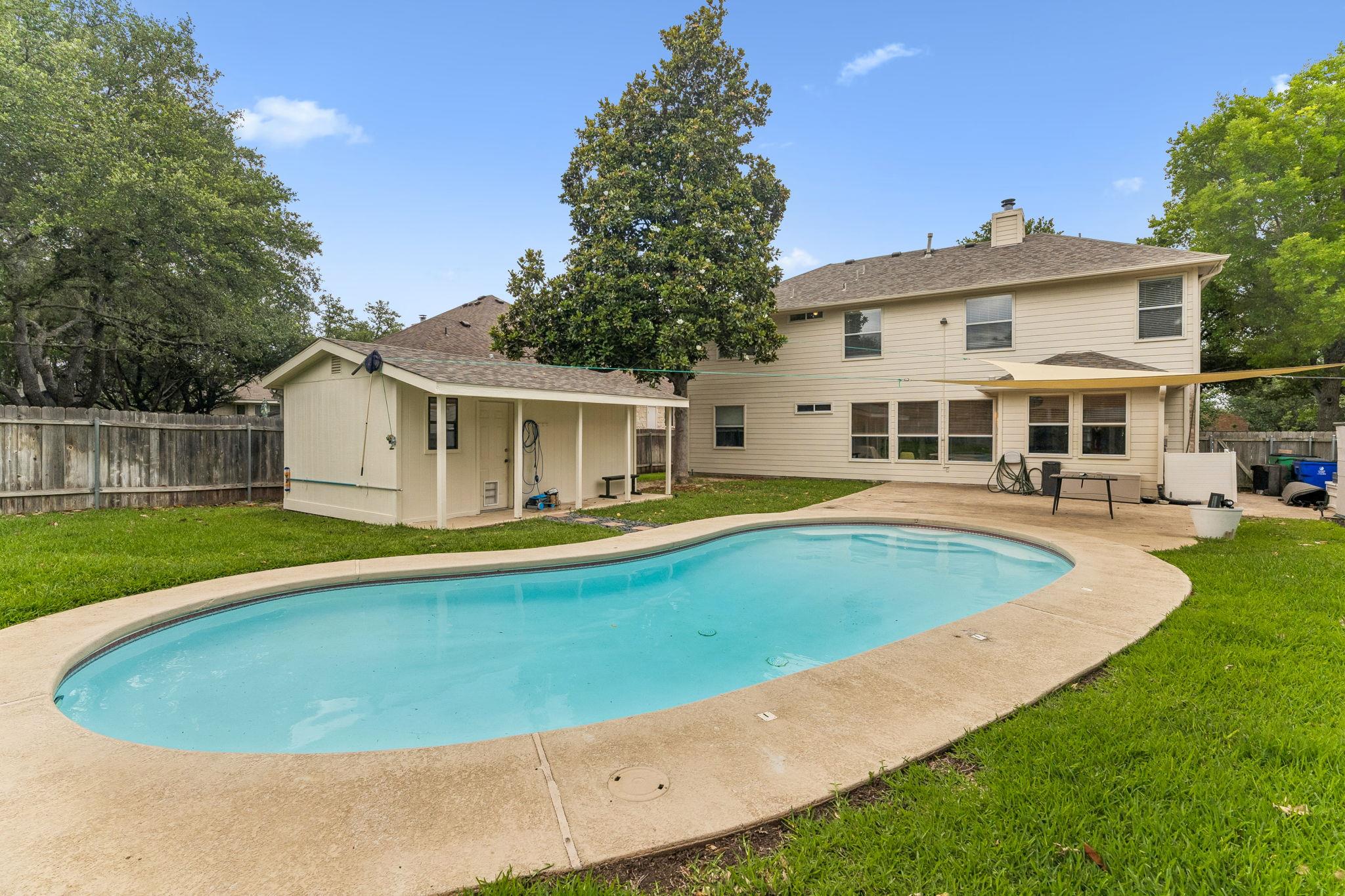 Expansive backyard featuring a large swimming poo