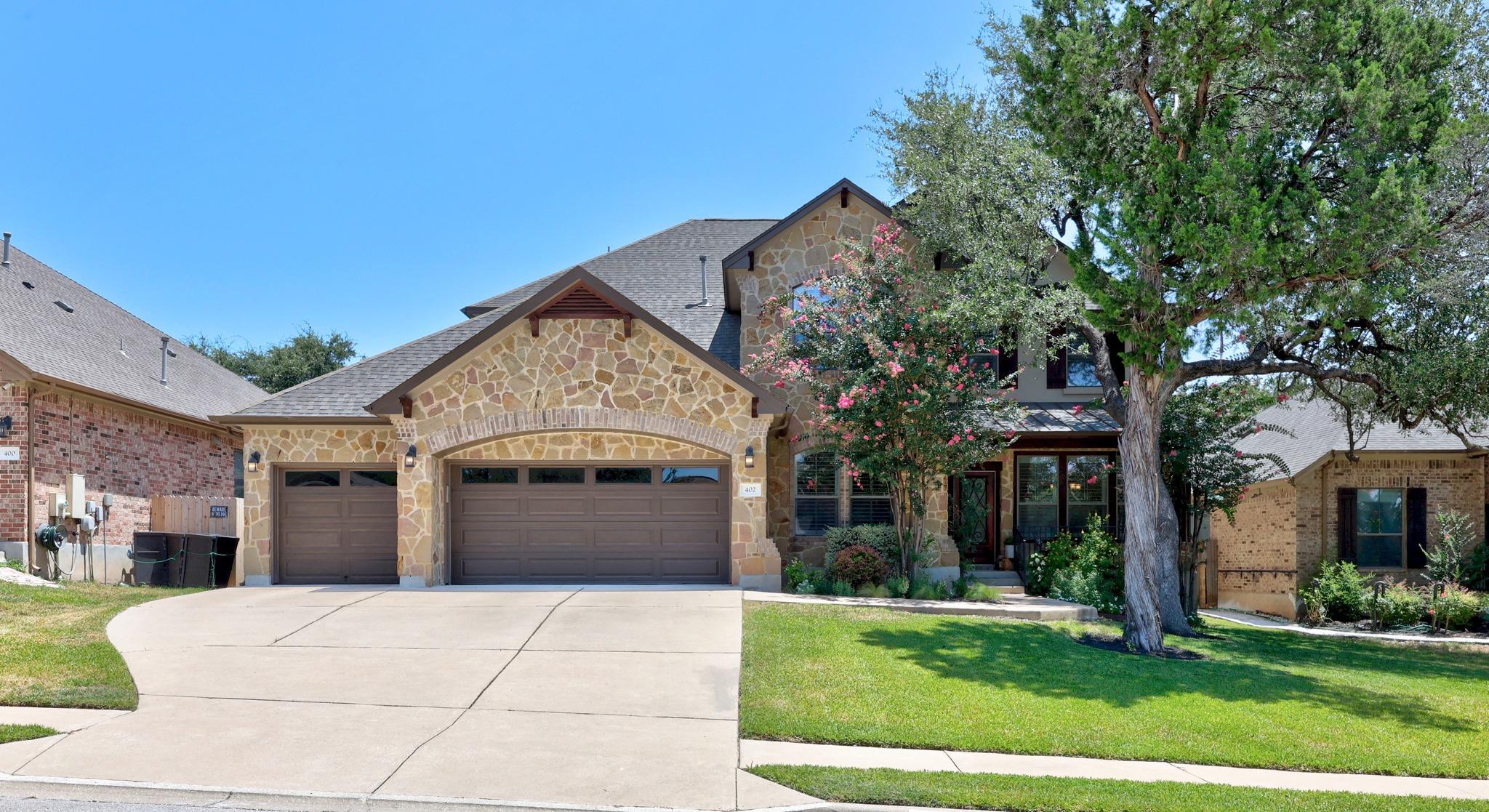 A striking stone facade and arched garage doors d