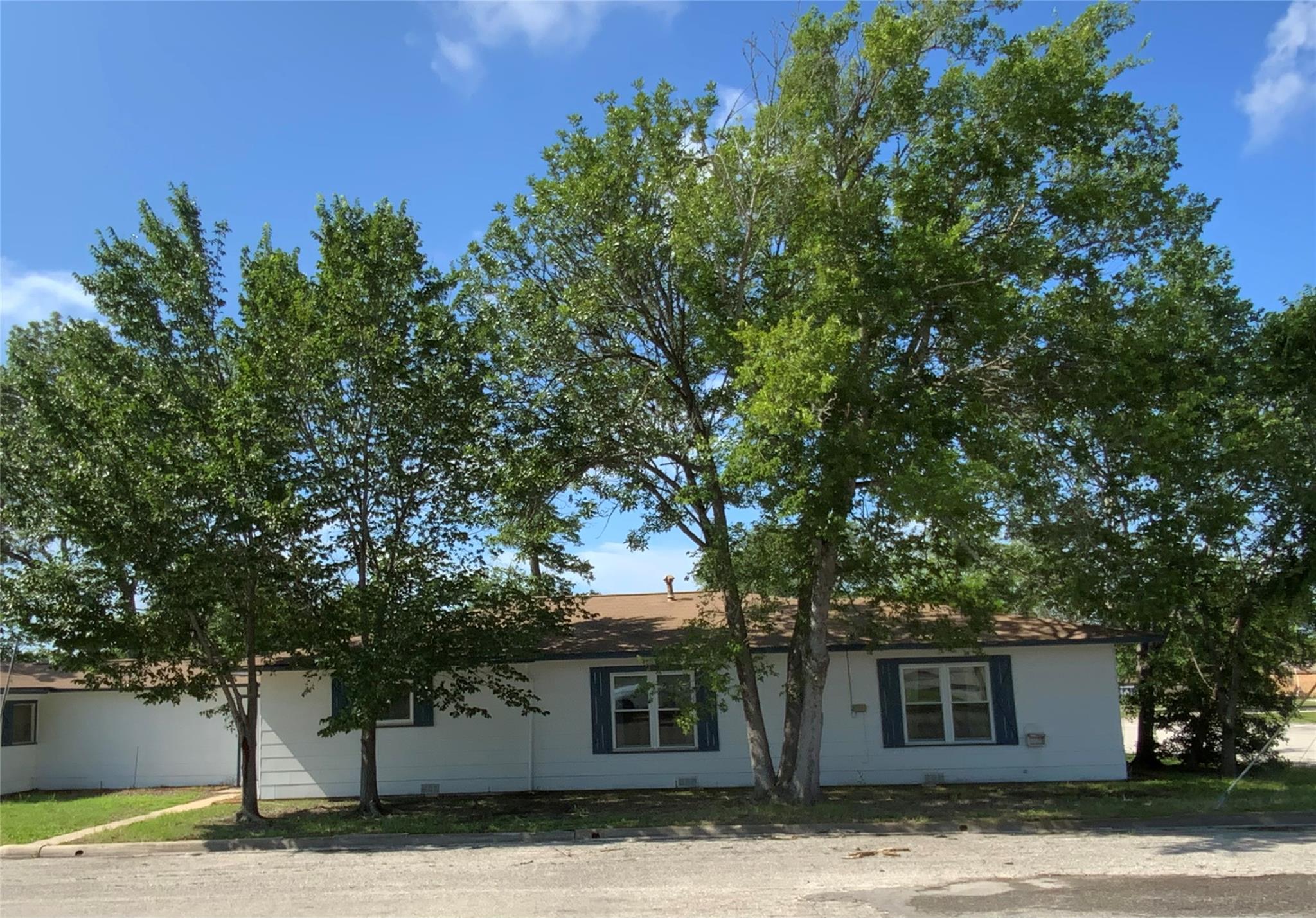 White siding exterior with a brown shingle roof, 