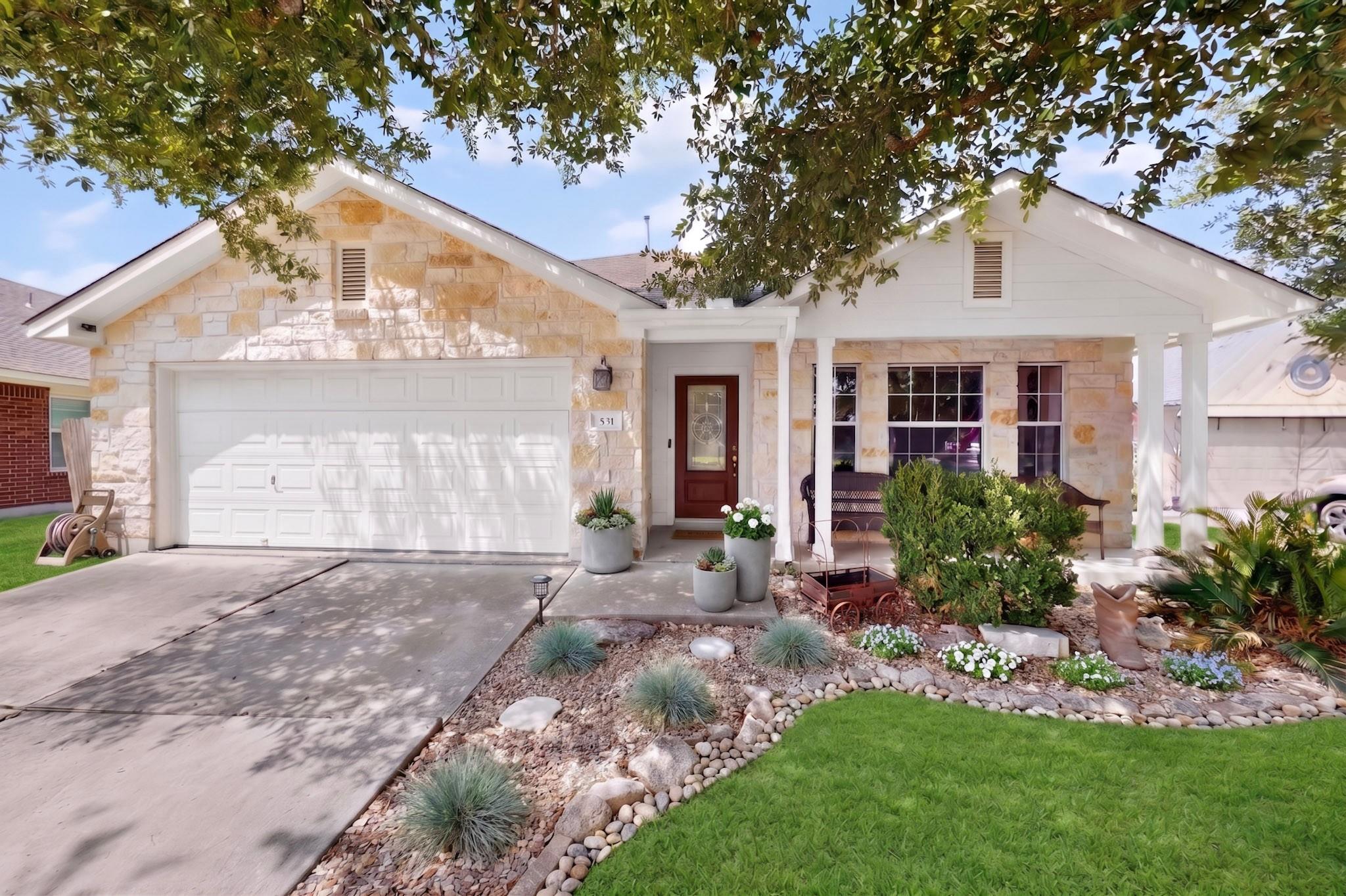 A welcoming stone facade and a manicured landscap