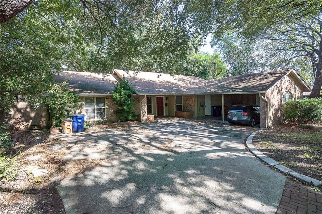 A classic brick exterior blends with mature trees