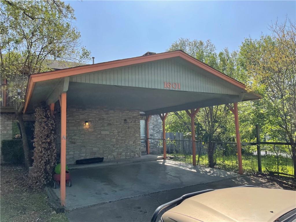 A stone-clad home features a generous carport wit