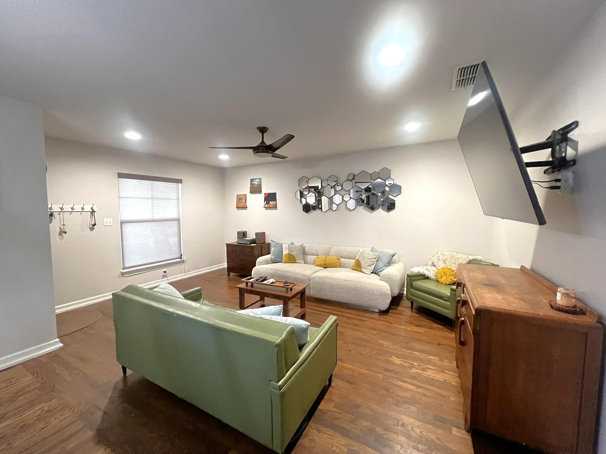 Living area with ceiling fan, wood finished floor