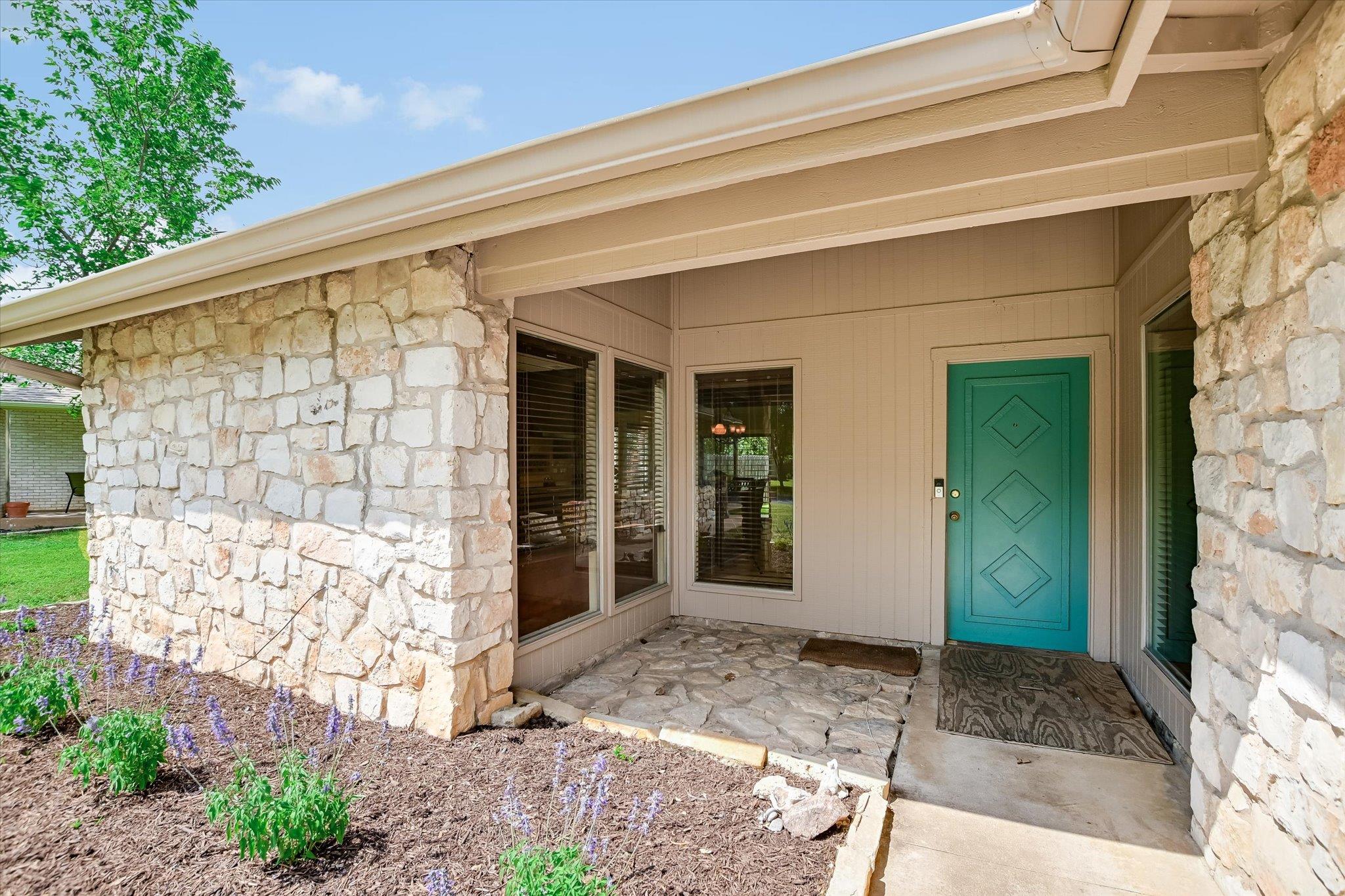 Stone veneer exterior featuring a turquoise entry
