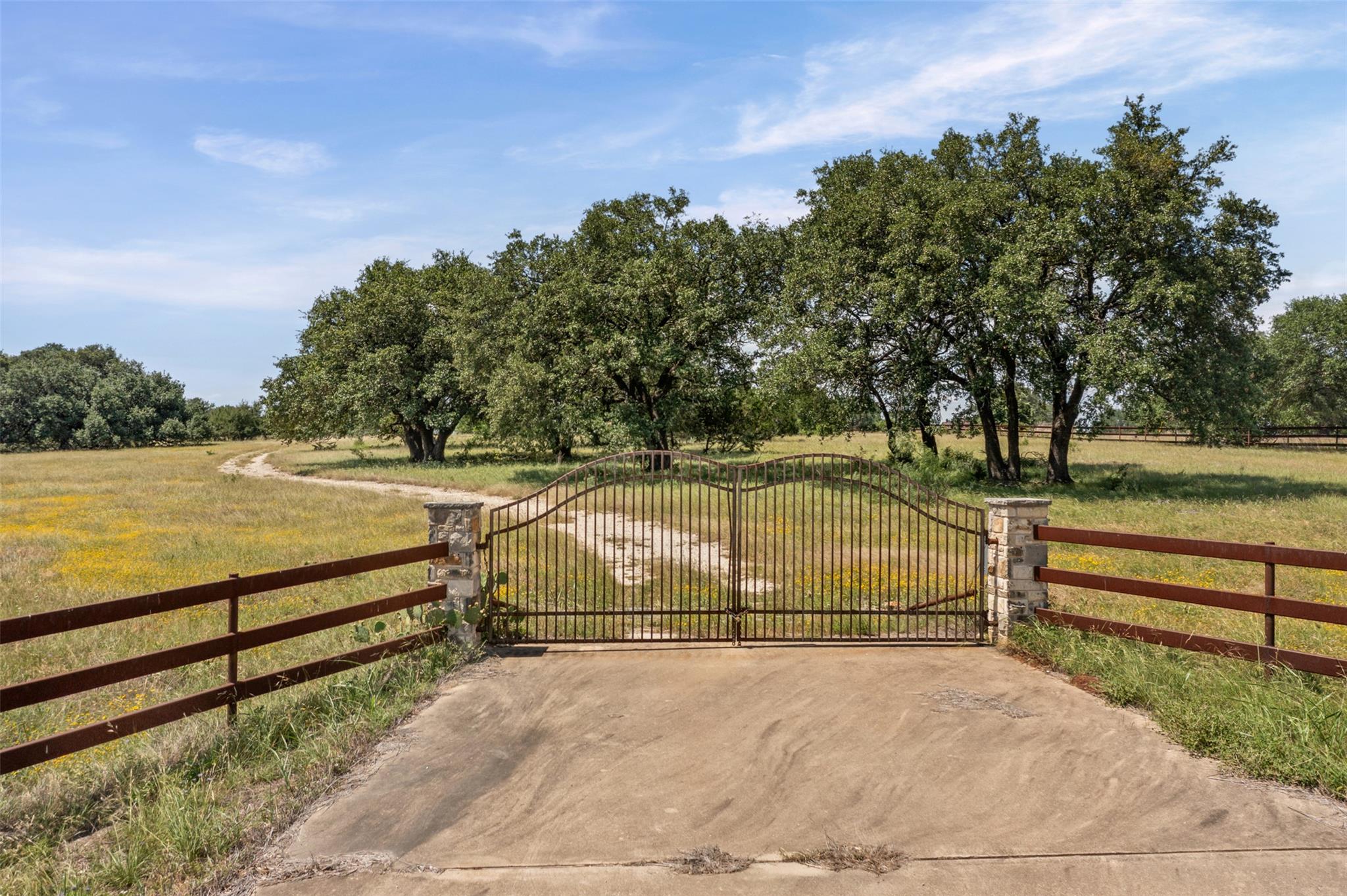 Wrought iron double gates with stone pillars open