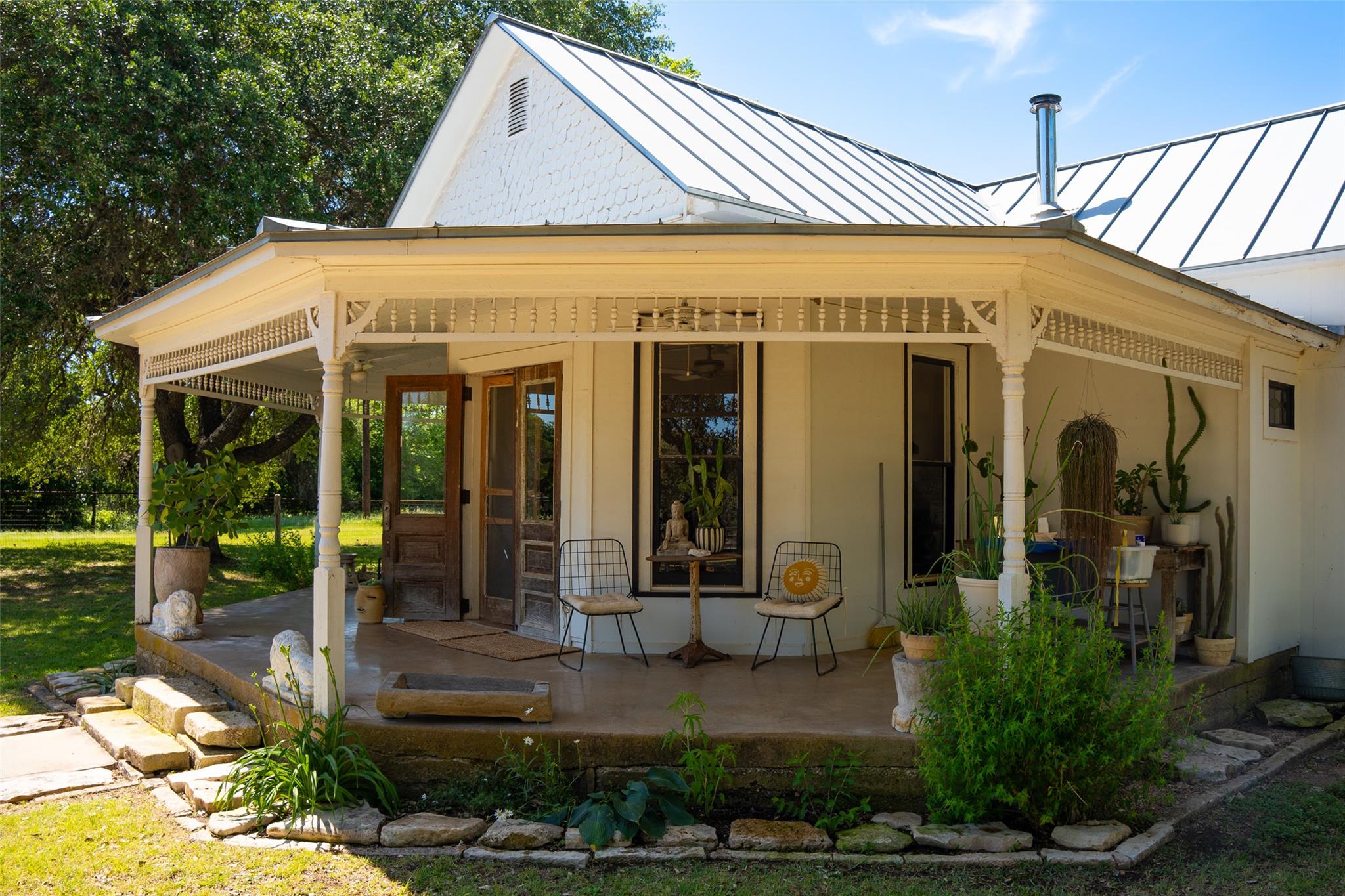 A welcoming front porch features ornate spindle d