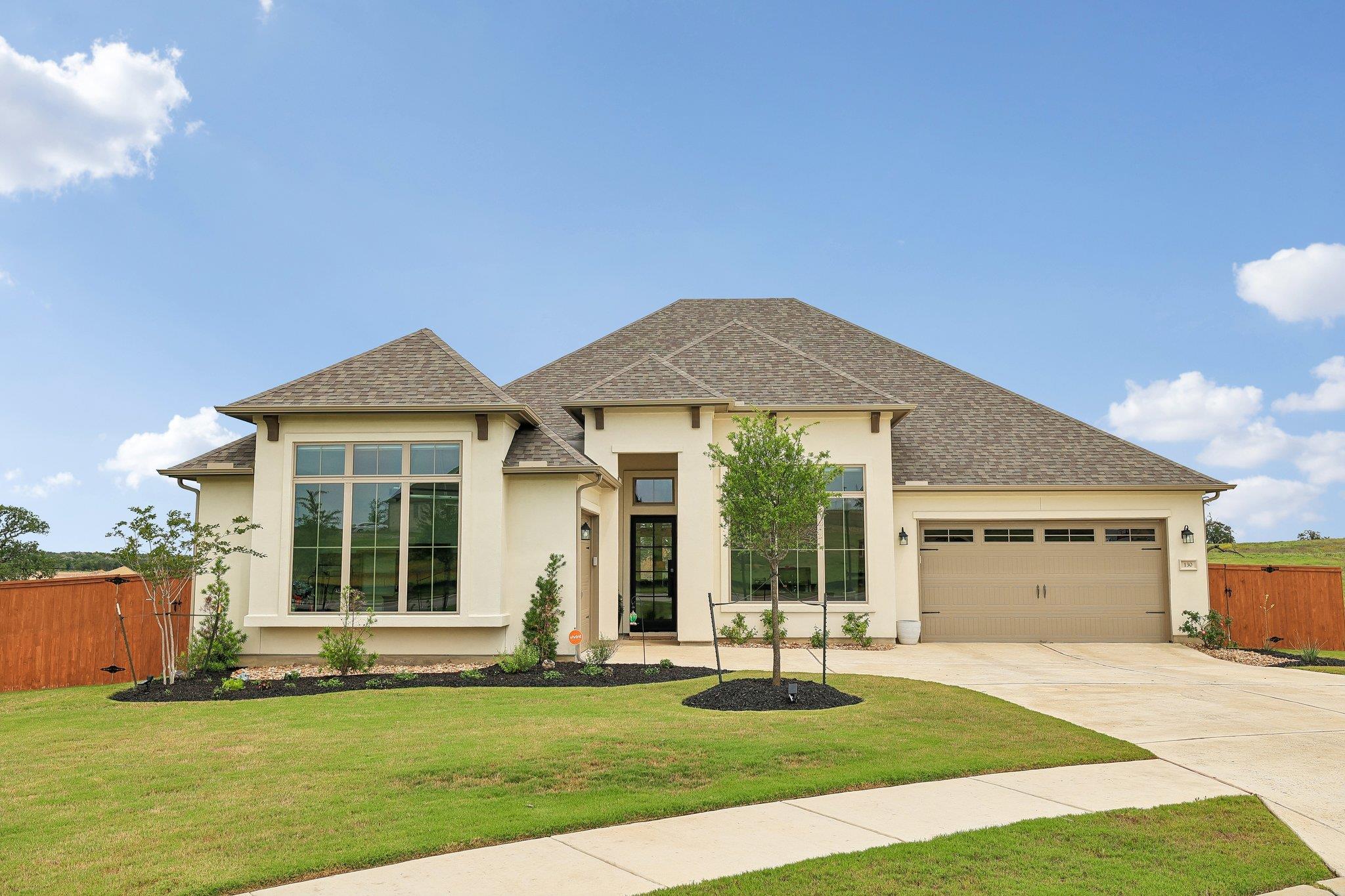 Stucco exterior with a hip roof and dark brown sh