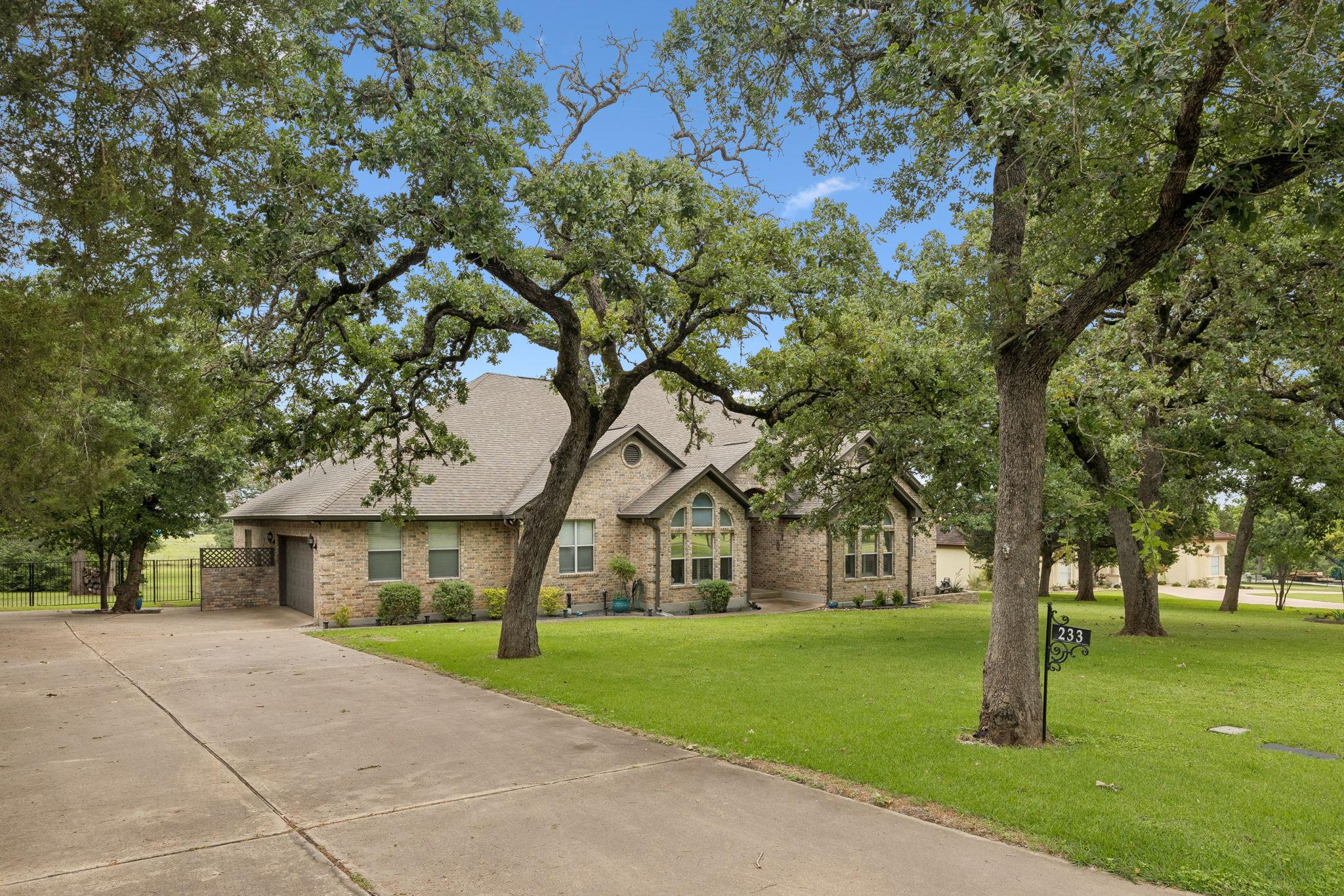 Mature trees canopy this inviting brick residence