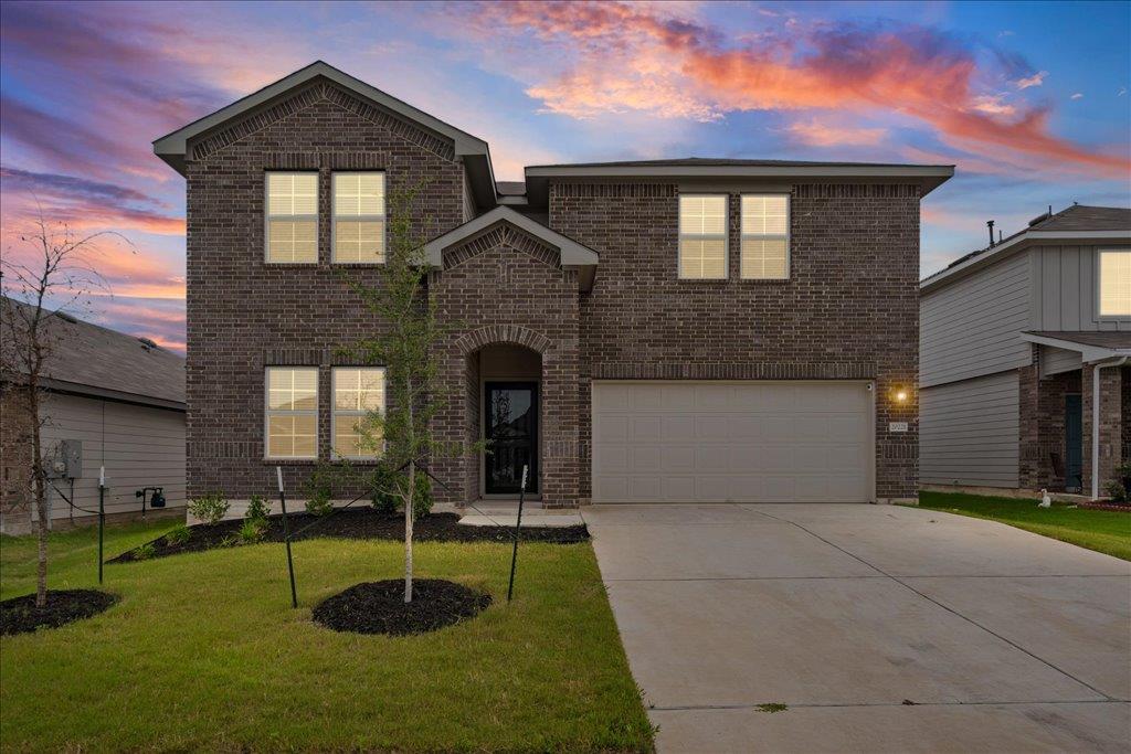Two-story brick exterior featuring a two-car gara