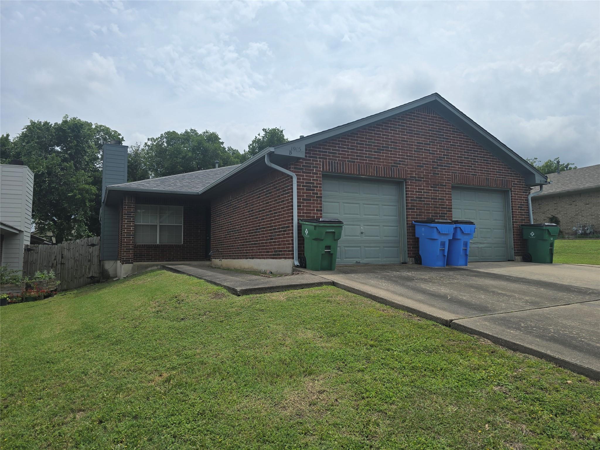 Brick exterior featuring a two-car garage with li