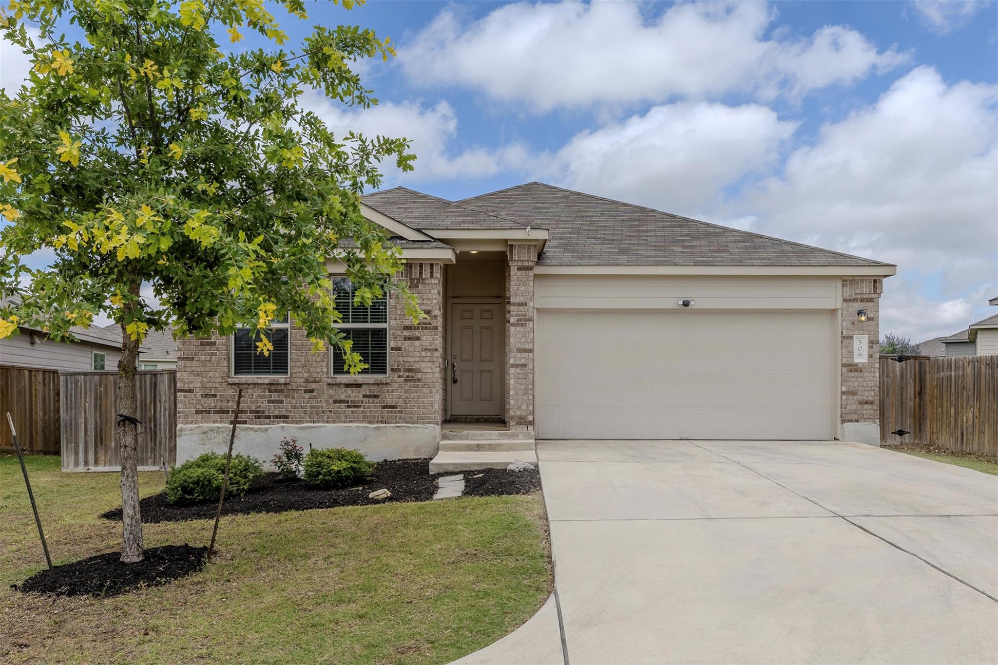 Brick veneer exterior featuring a two-car garage,
