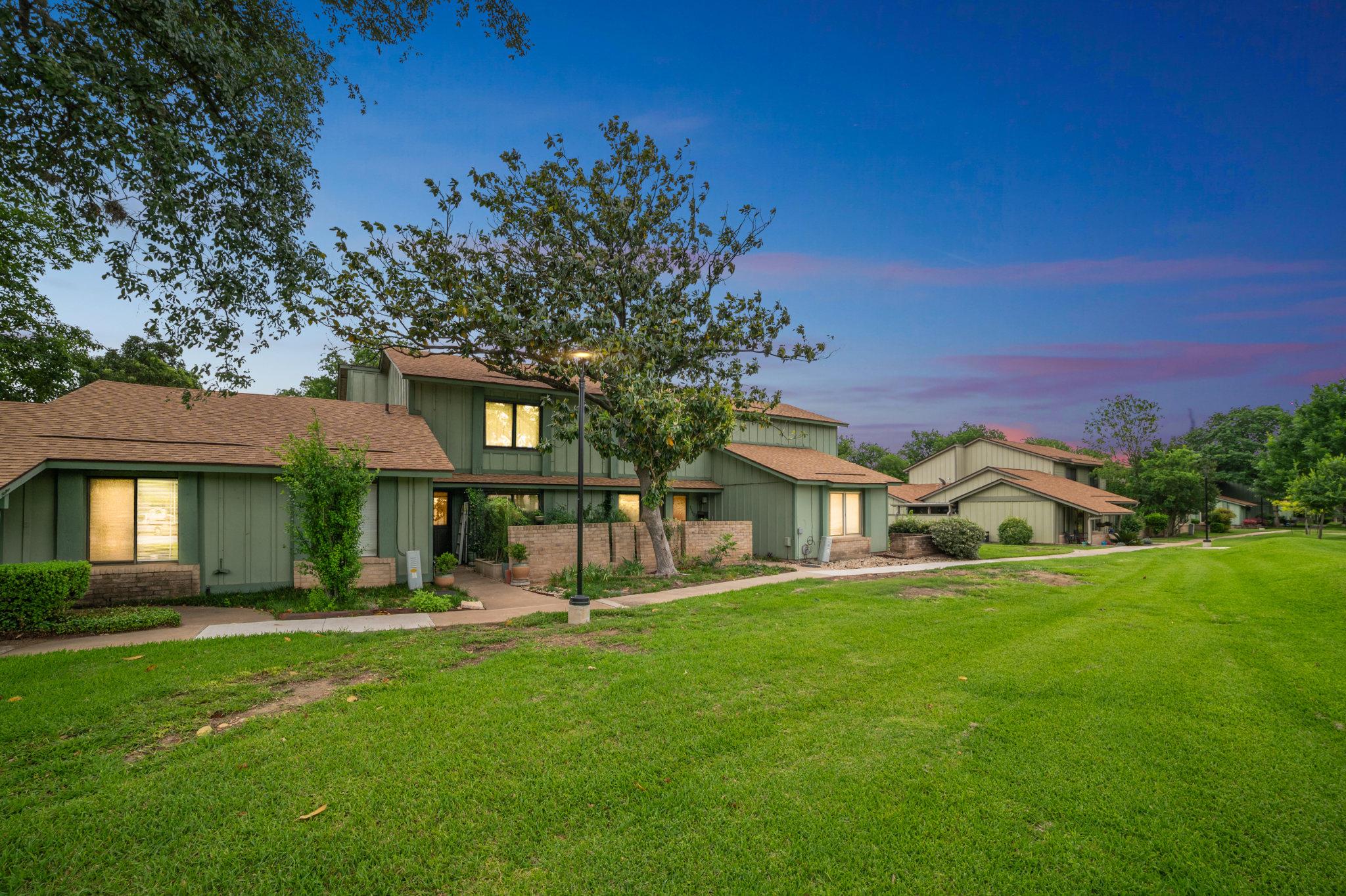 Exterior featuring green siding, brown shingle ro
