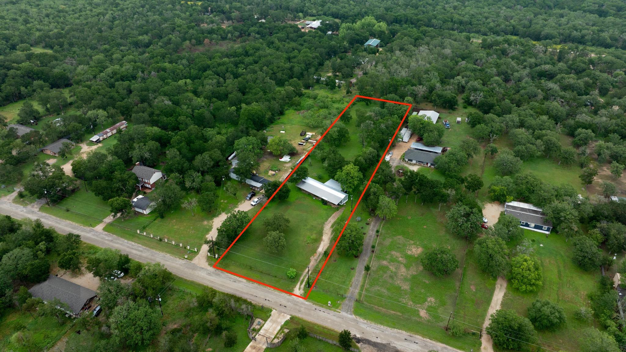 Expansive parcel featuring mature trees, a drivew