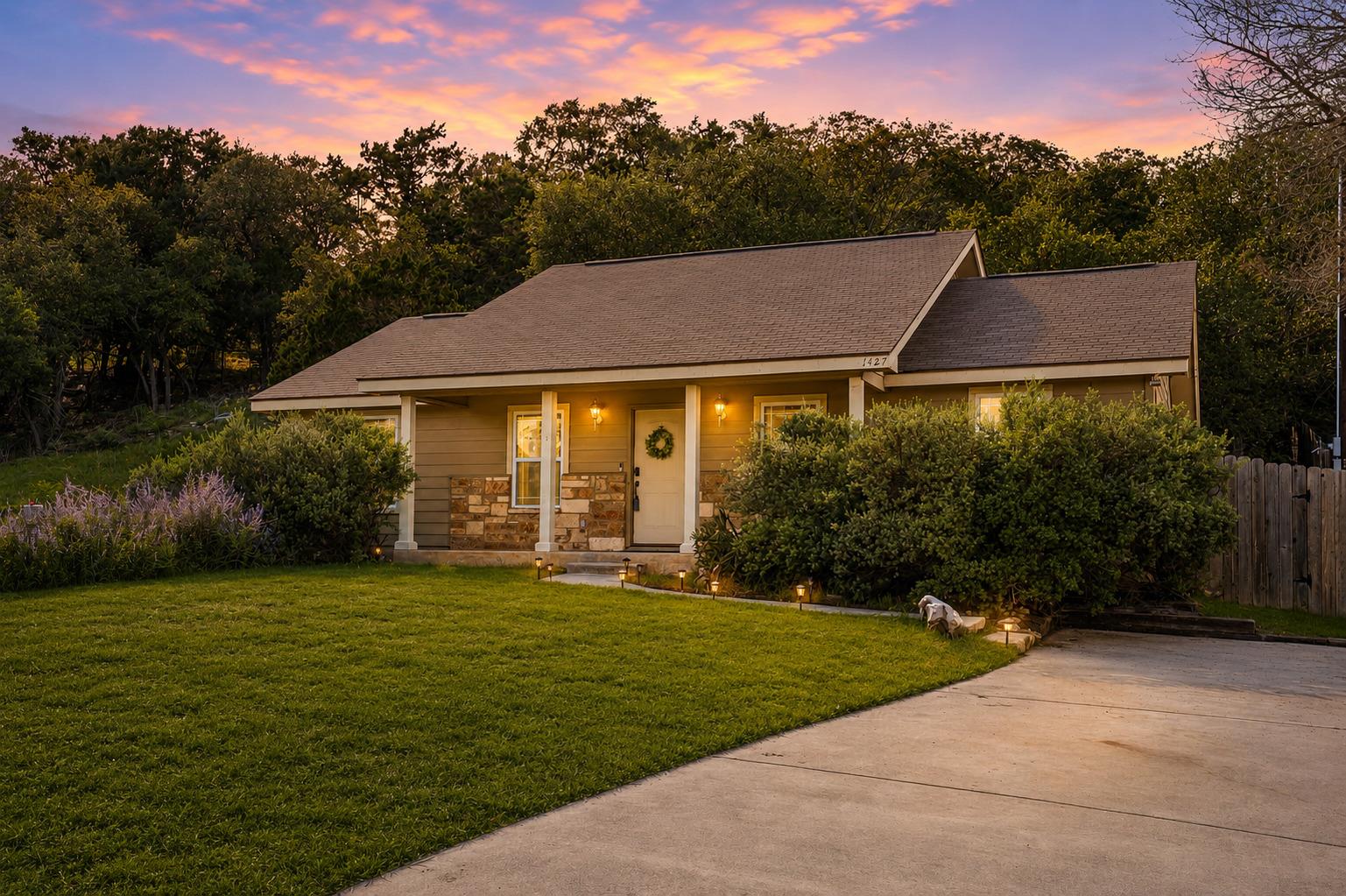 An inviting exterior with a manicured lawn, stone