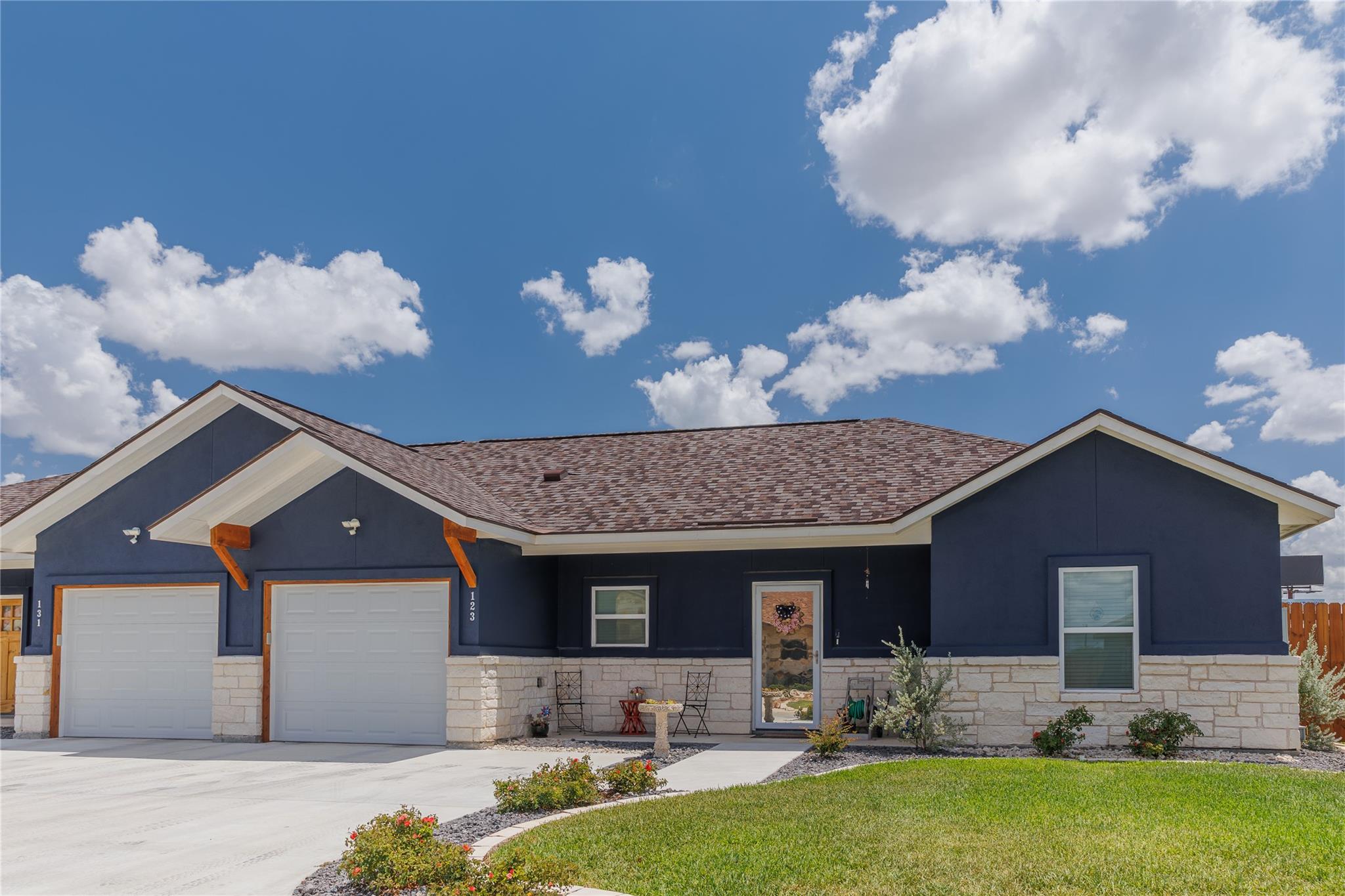 A striking dark blue exterior with light stone ac