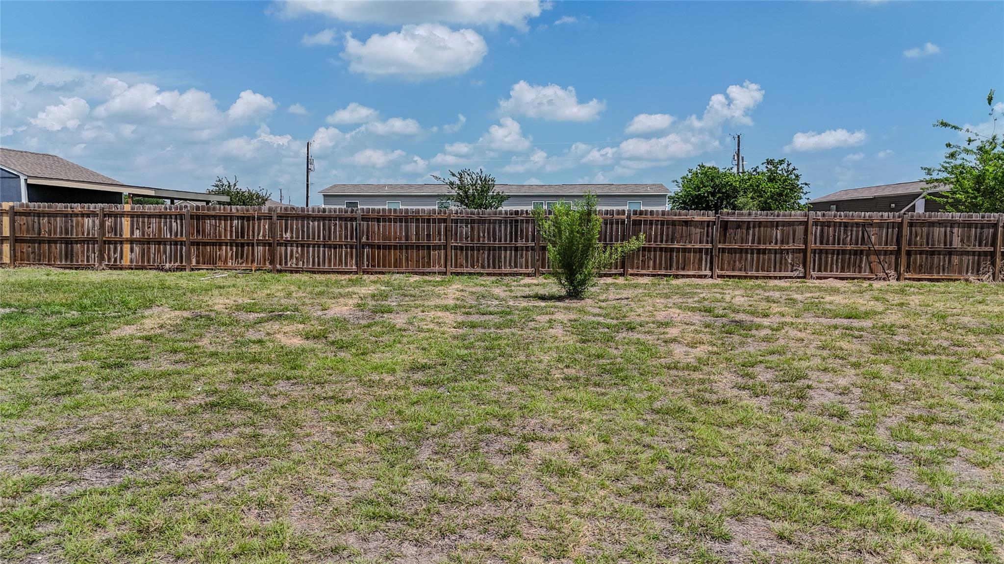 Secure yard featuring a sturdy wood fence, provid