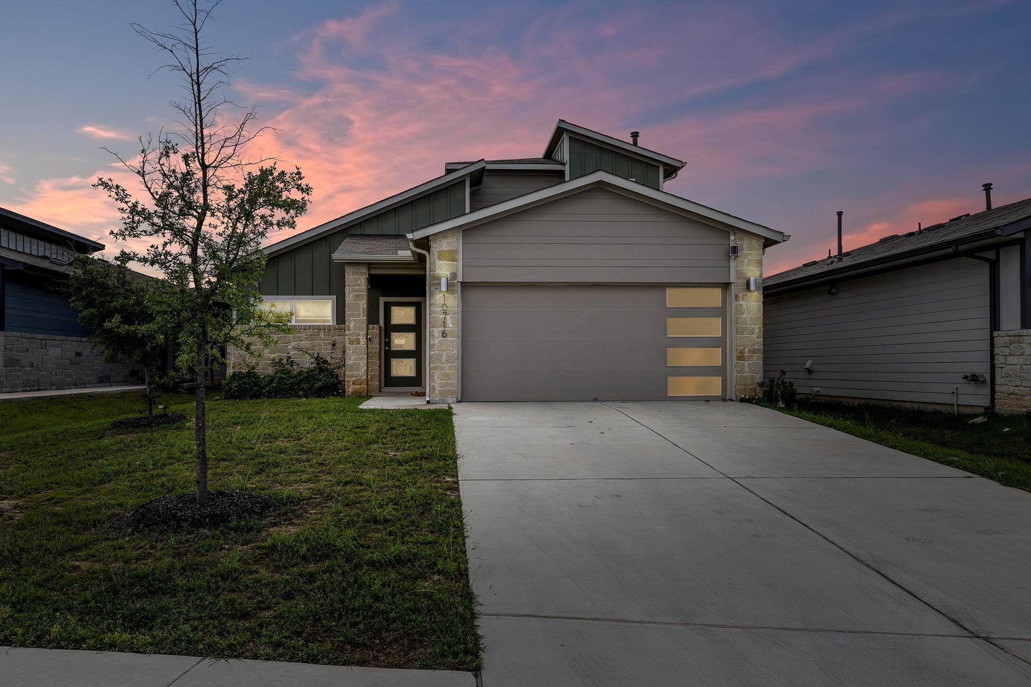 Modern facade with a garage and a lush front yard