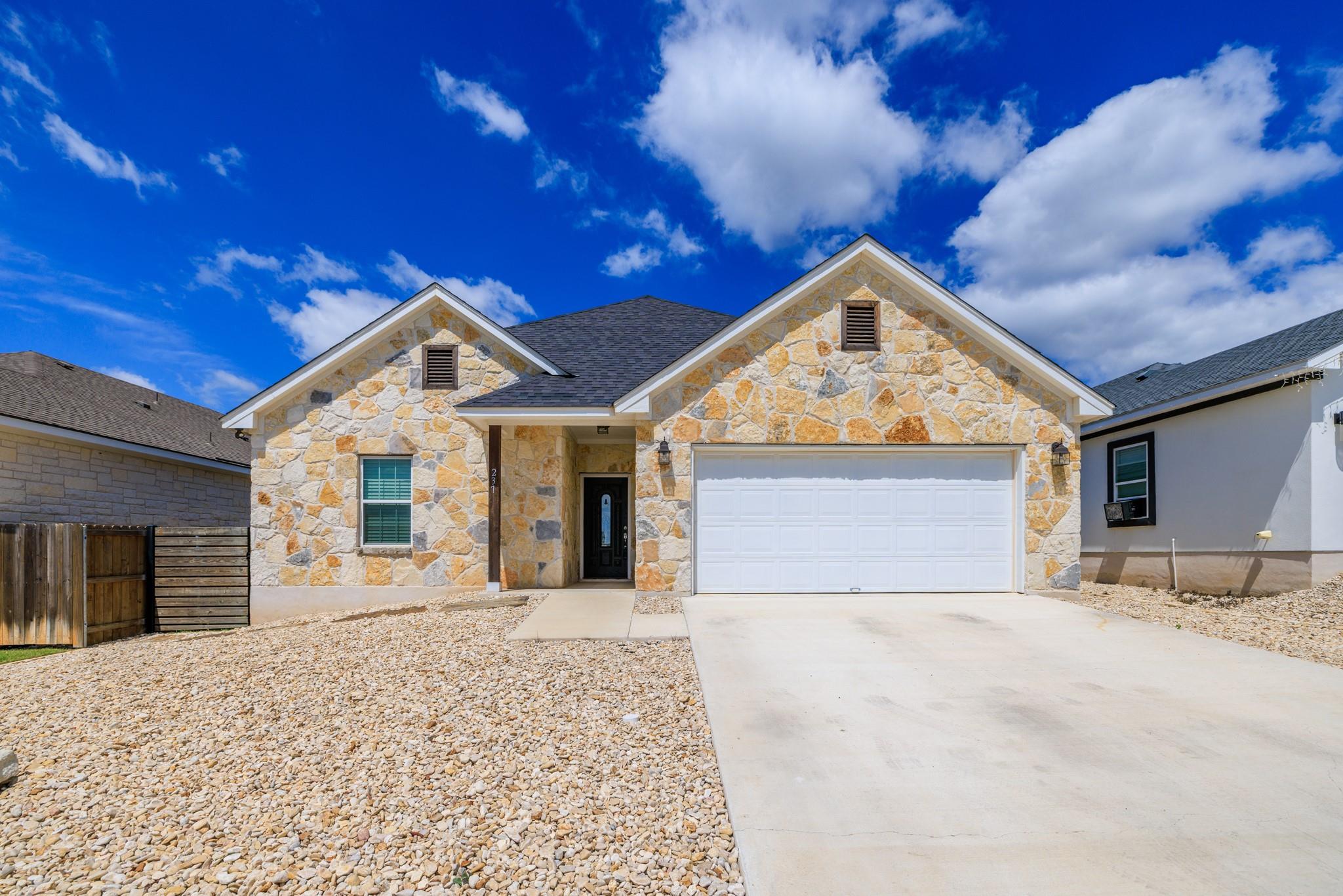 A striking stone facade with a prominent two-car 