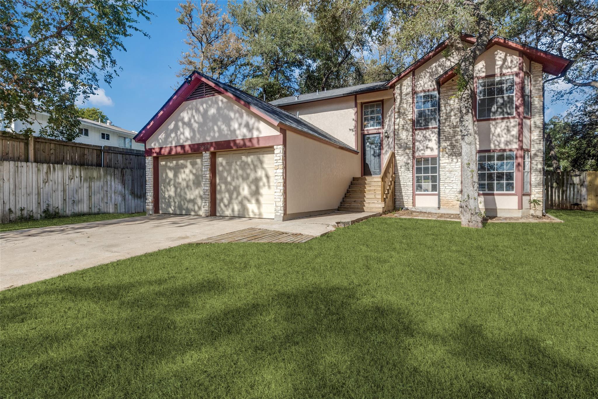 Mature trees frame this multi-level exterior feat