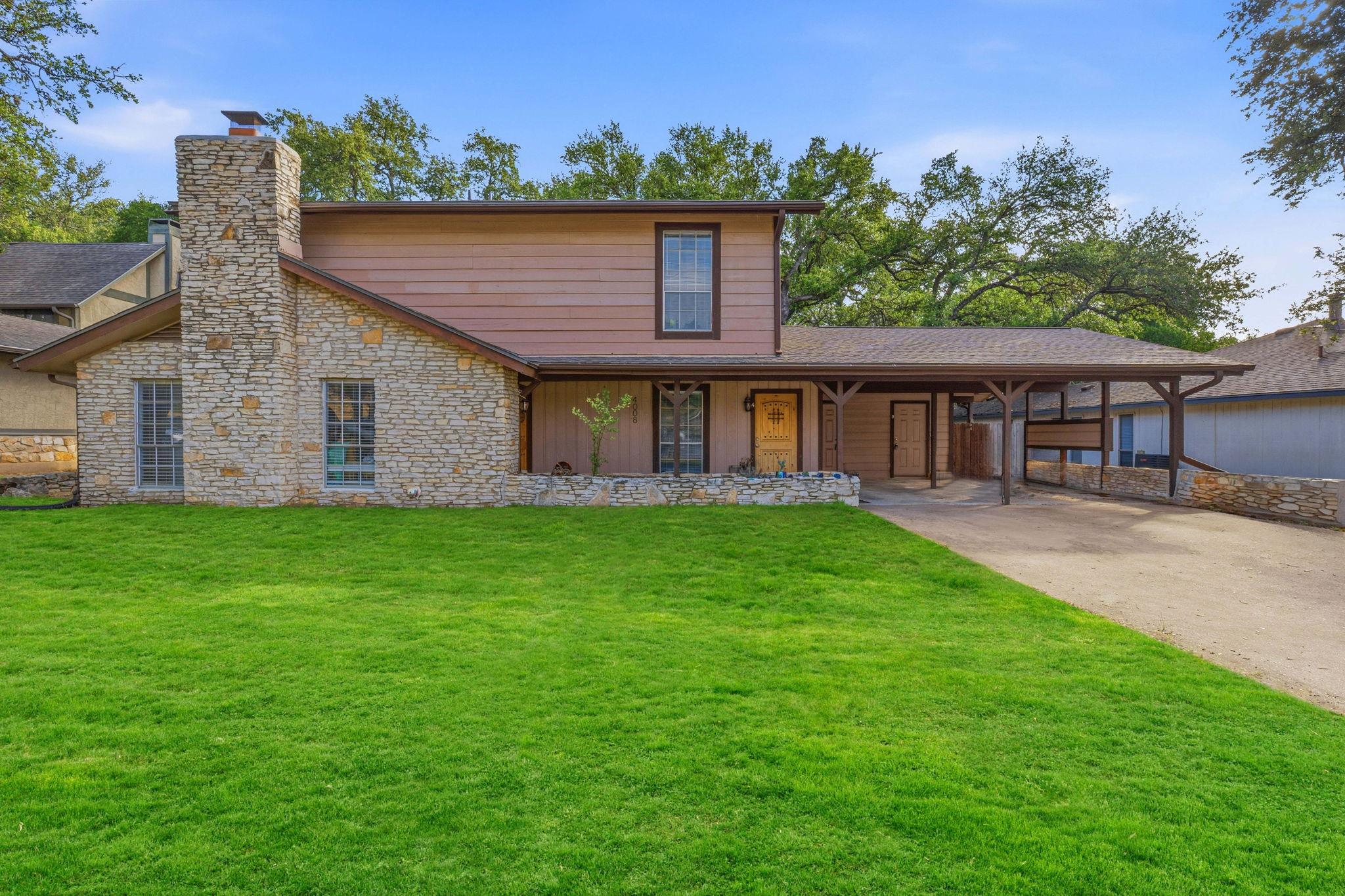 A charming home boasts a striking stone chimney a