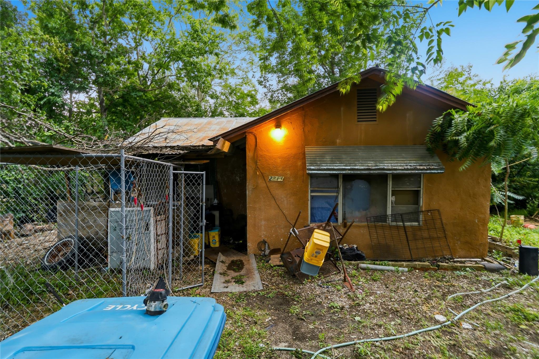 A modest stucco exterior, surrounded by lush, mat