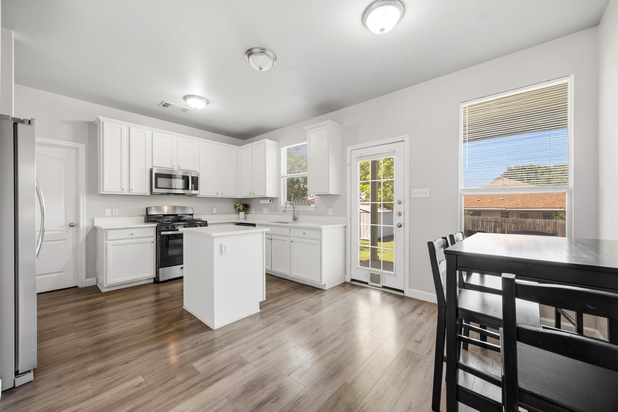 A well-lit kitchen with modern white cabinetry an