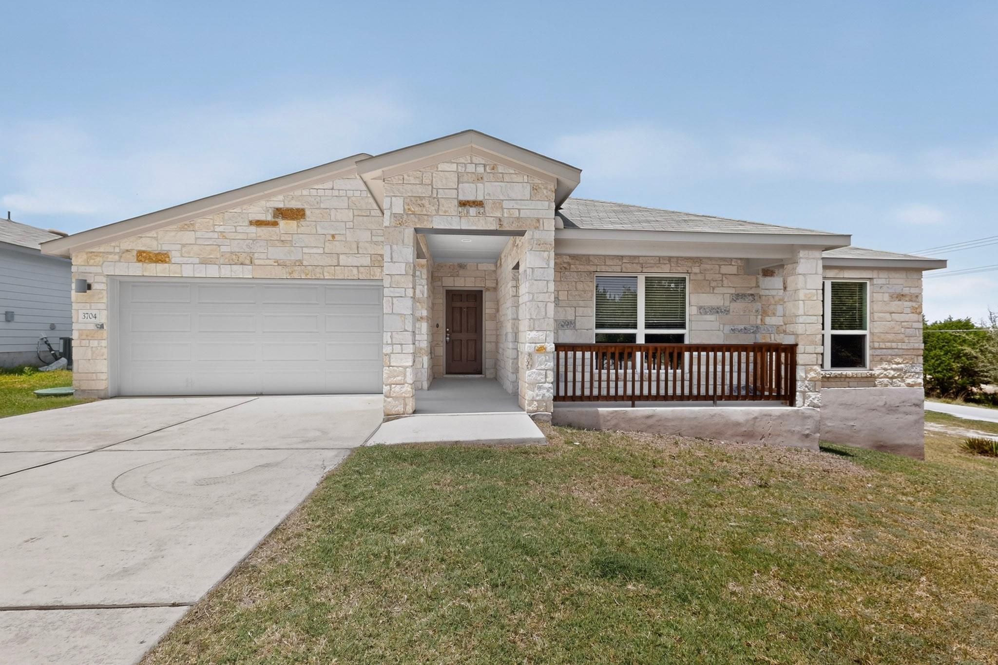 A single-story home featuring a classic stone fac