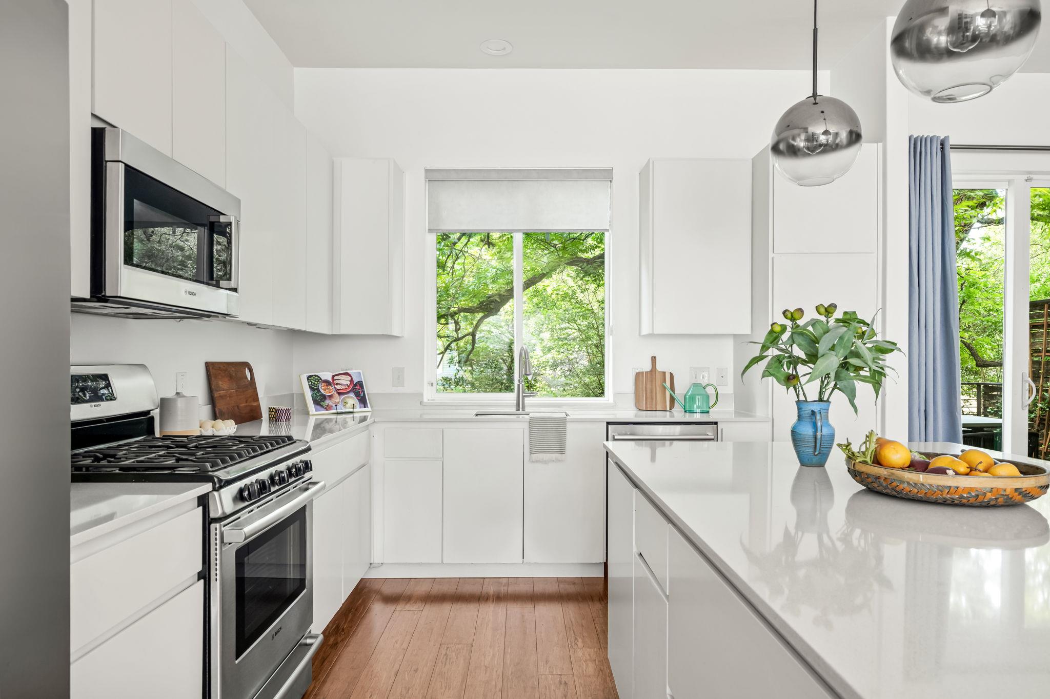 Modern kitchen with sleek white cabinetry, gleami