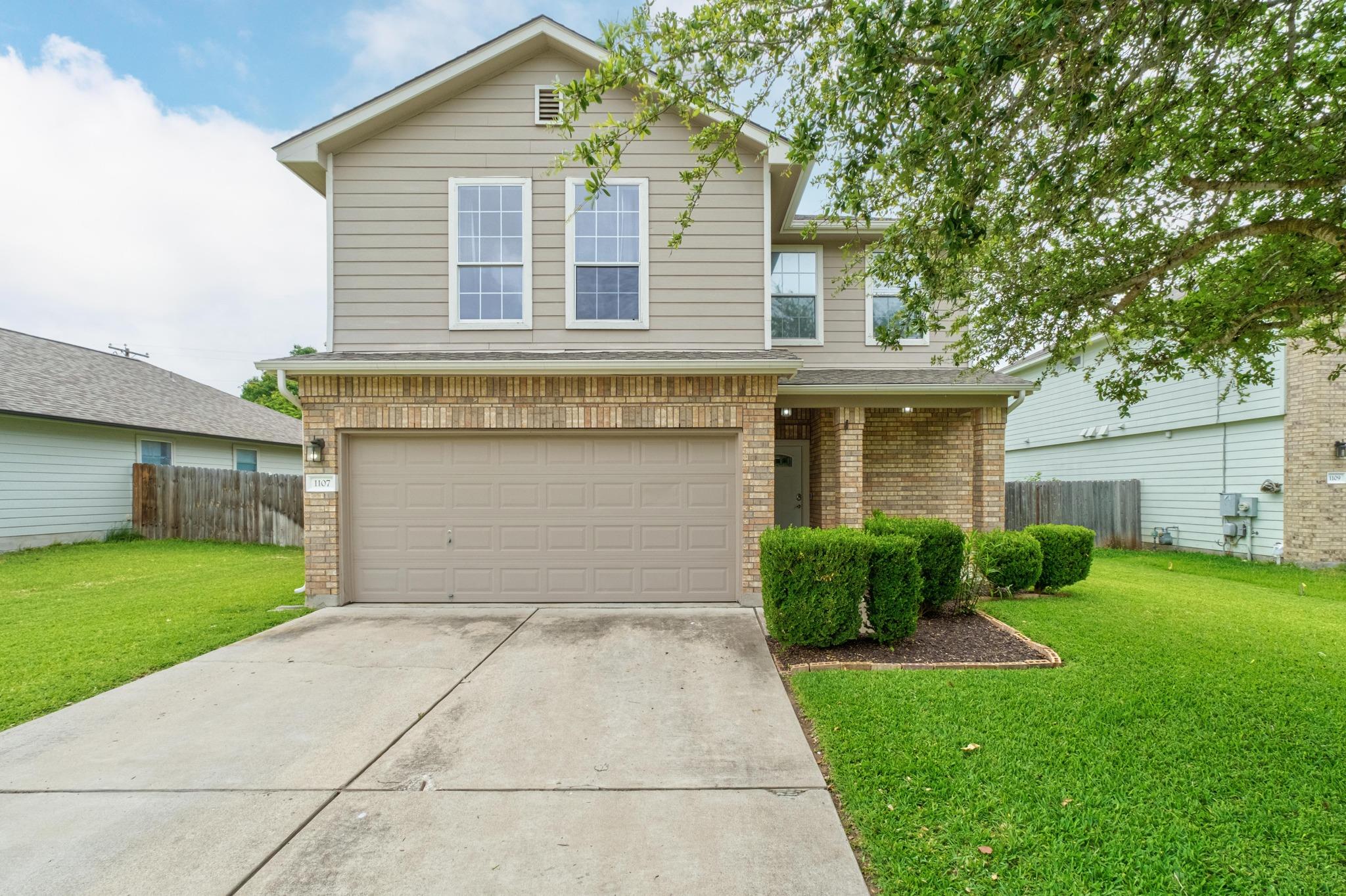 A classic two-story home with a neat lawn and an 