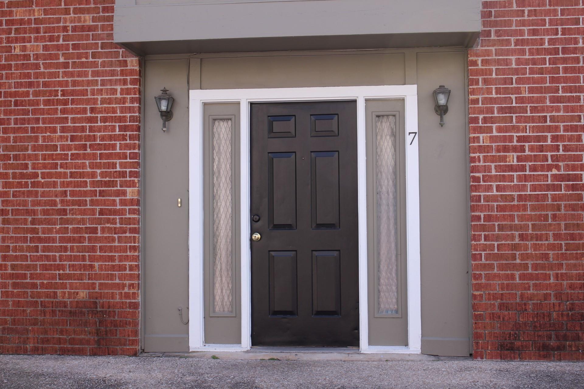 A classic six-panel entry door welcomes guests, f
