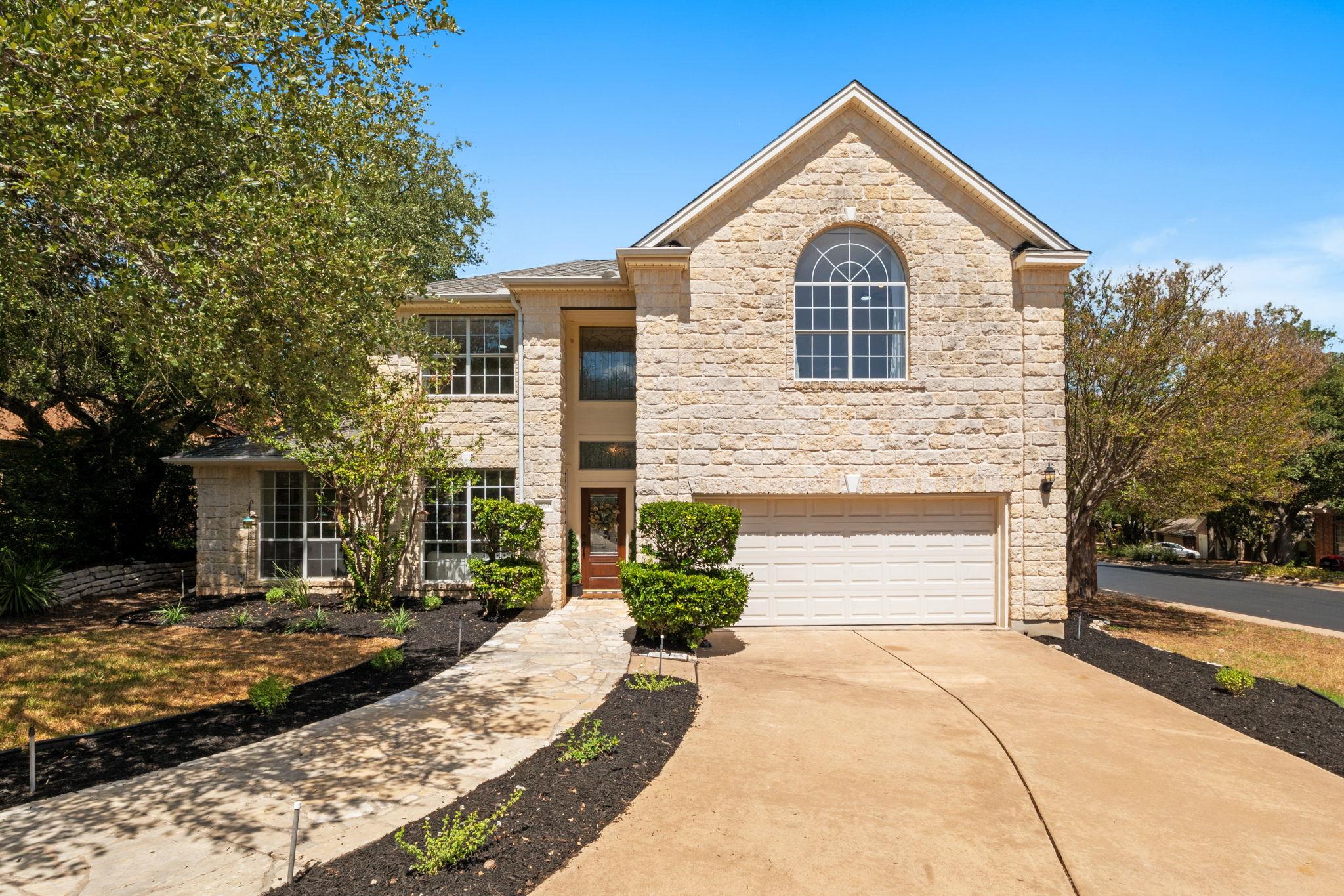 Textured stone siding and arched windows create a