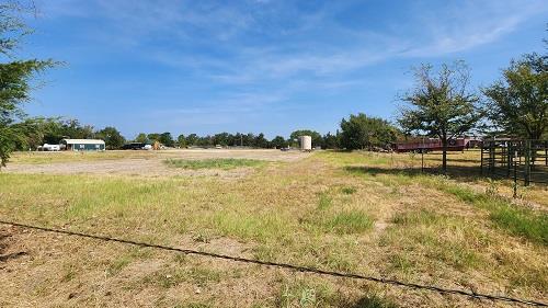 A spacious, undeveloped lot with distant building