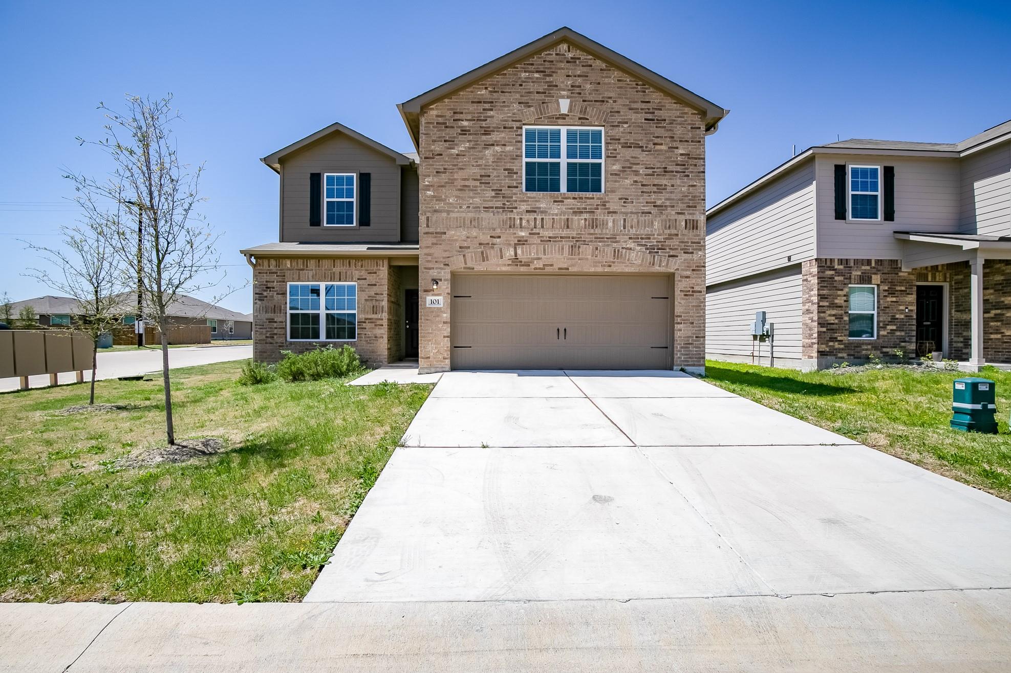 A classic brick facade and a two-car garage welco