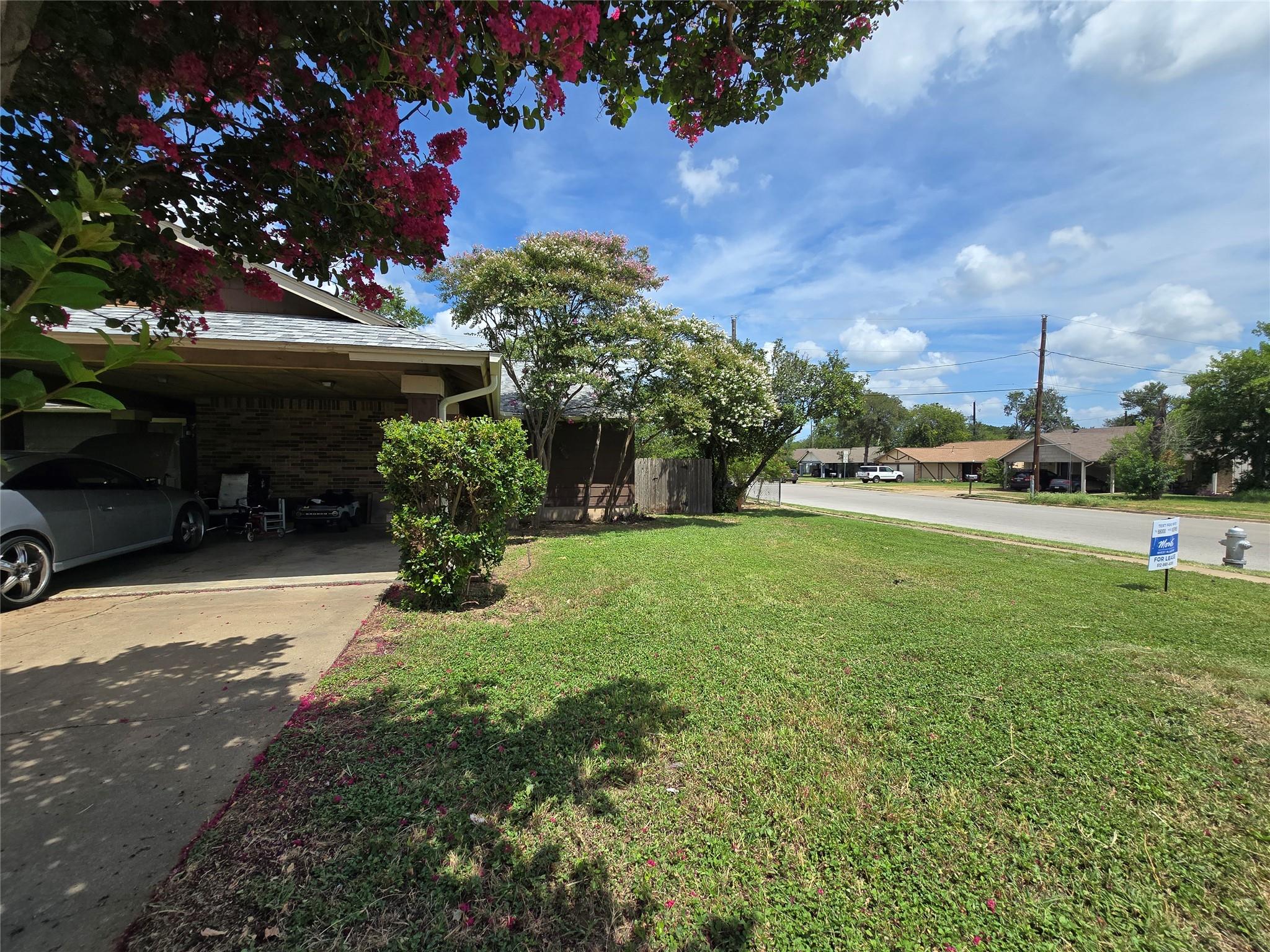 A well-maintained lawn and carport welcome you to