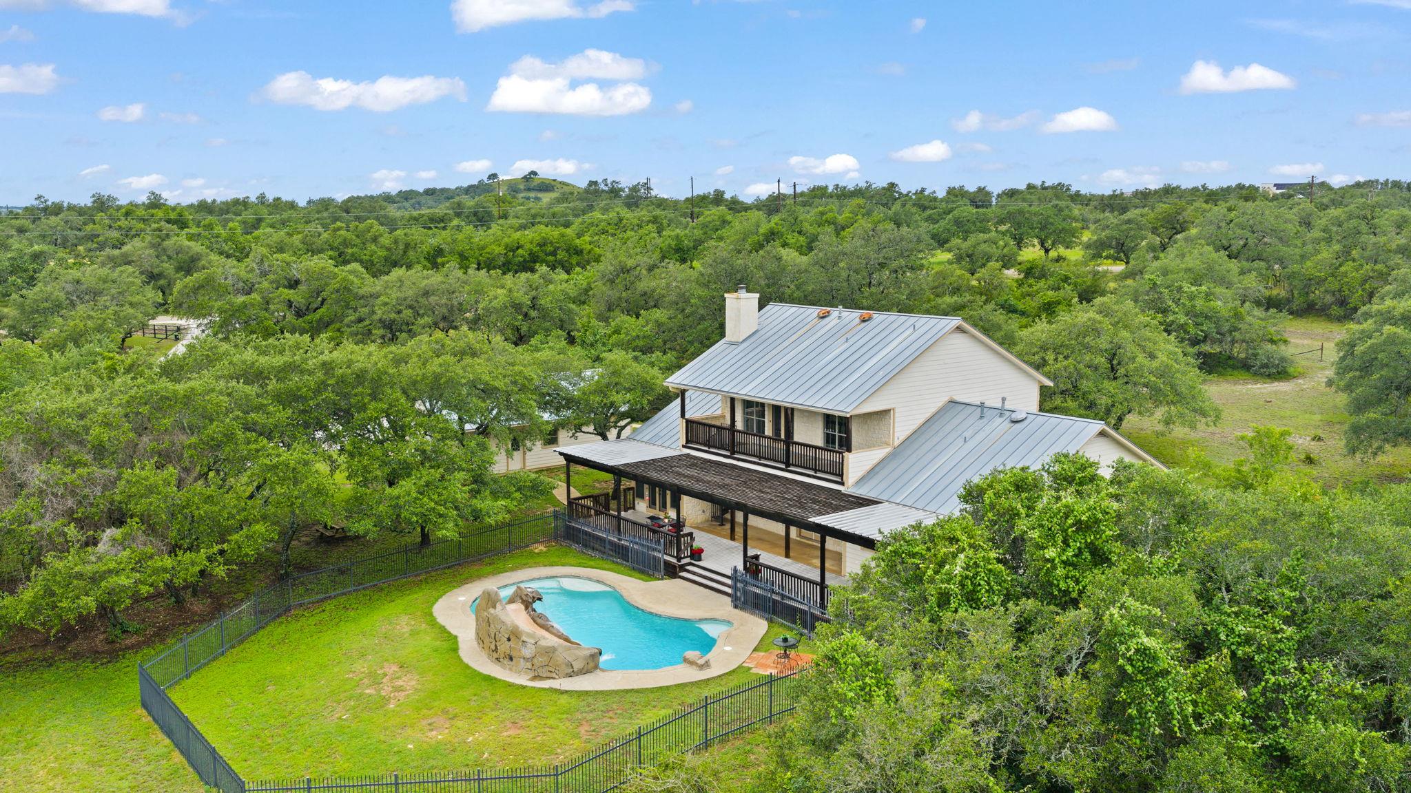 Perched amidst a verdant landscape, this home fea