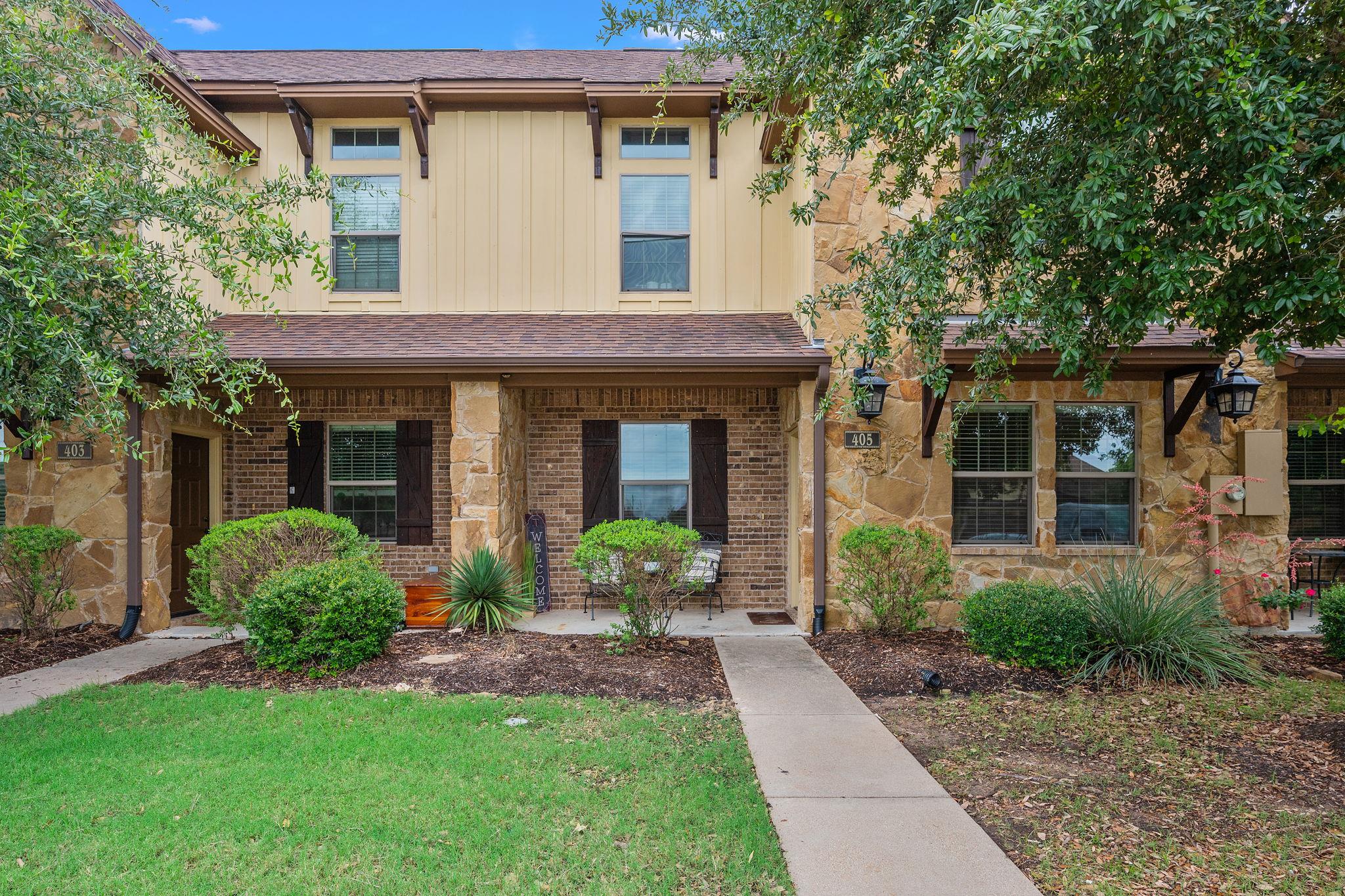 A welcoming stone and brick facade with rich land