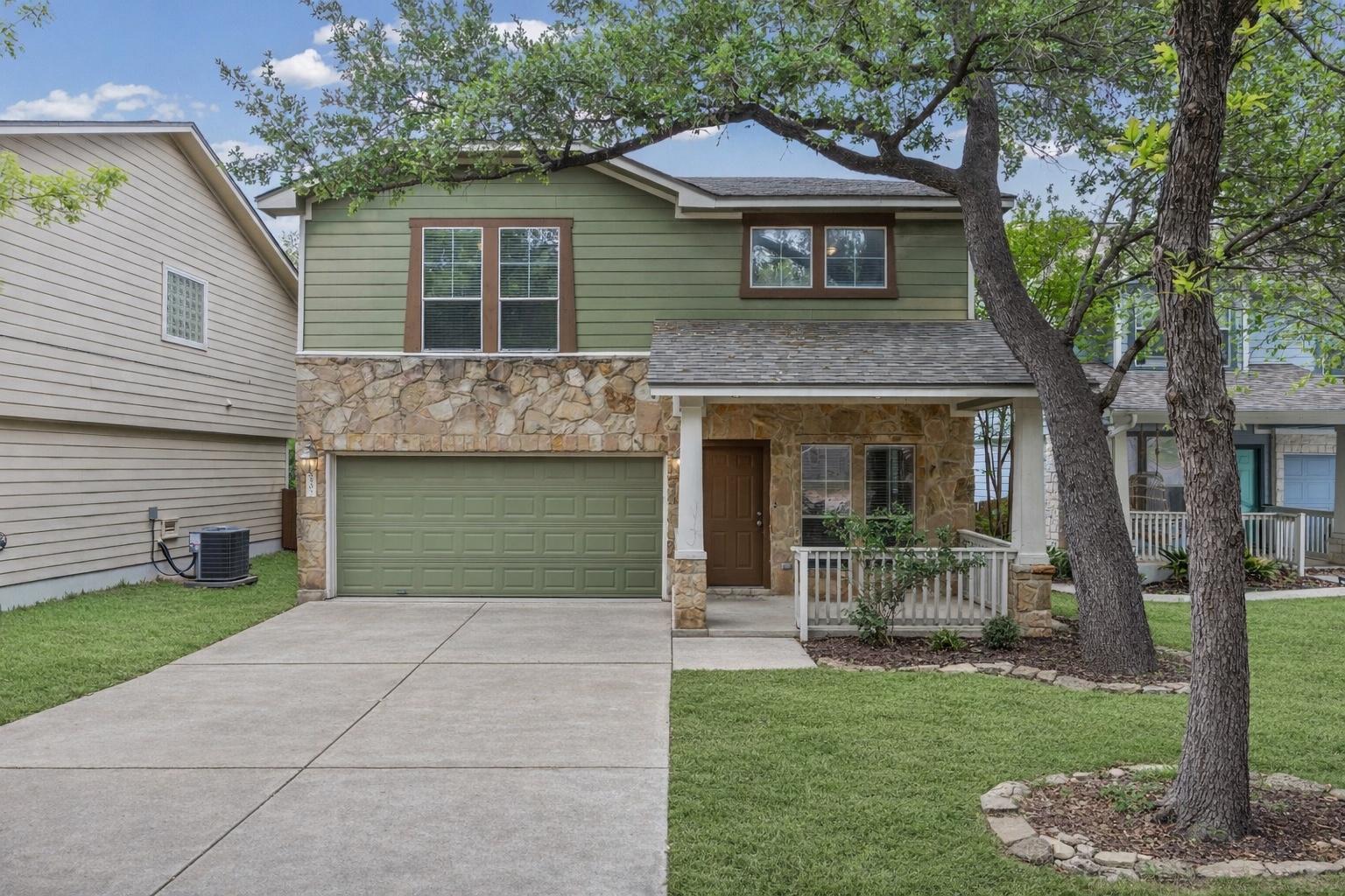 Green siding and natural stone accents adorn this