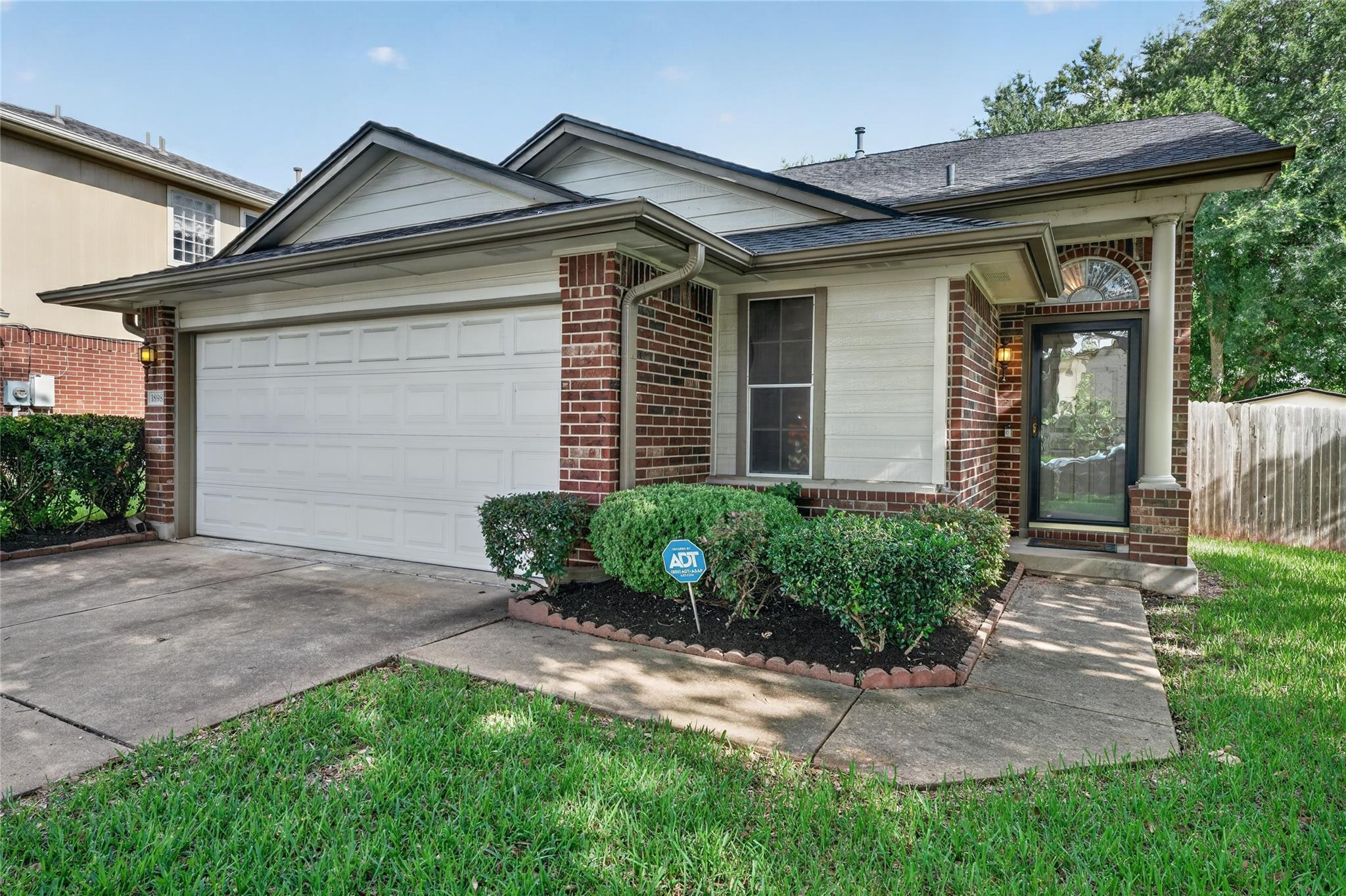 A classic brick and siding home presents a welcom
