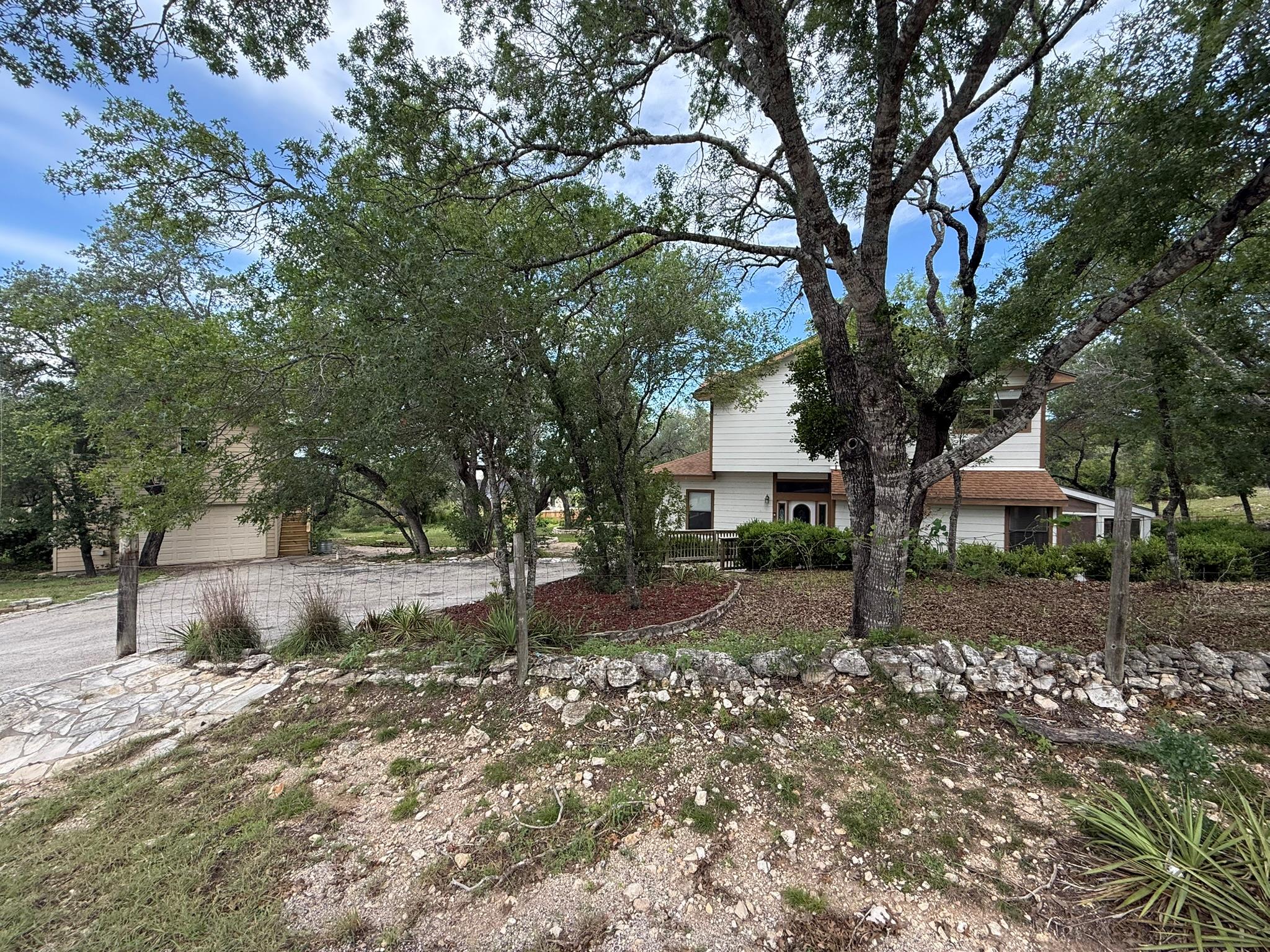 Mature trees frame this inviting two-story home w