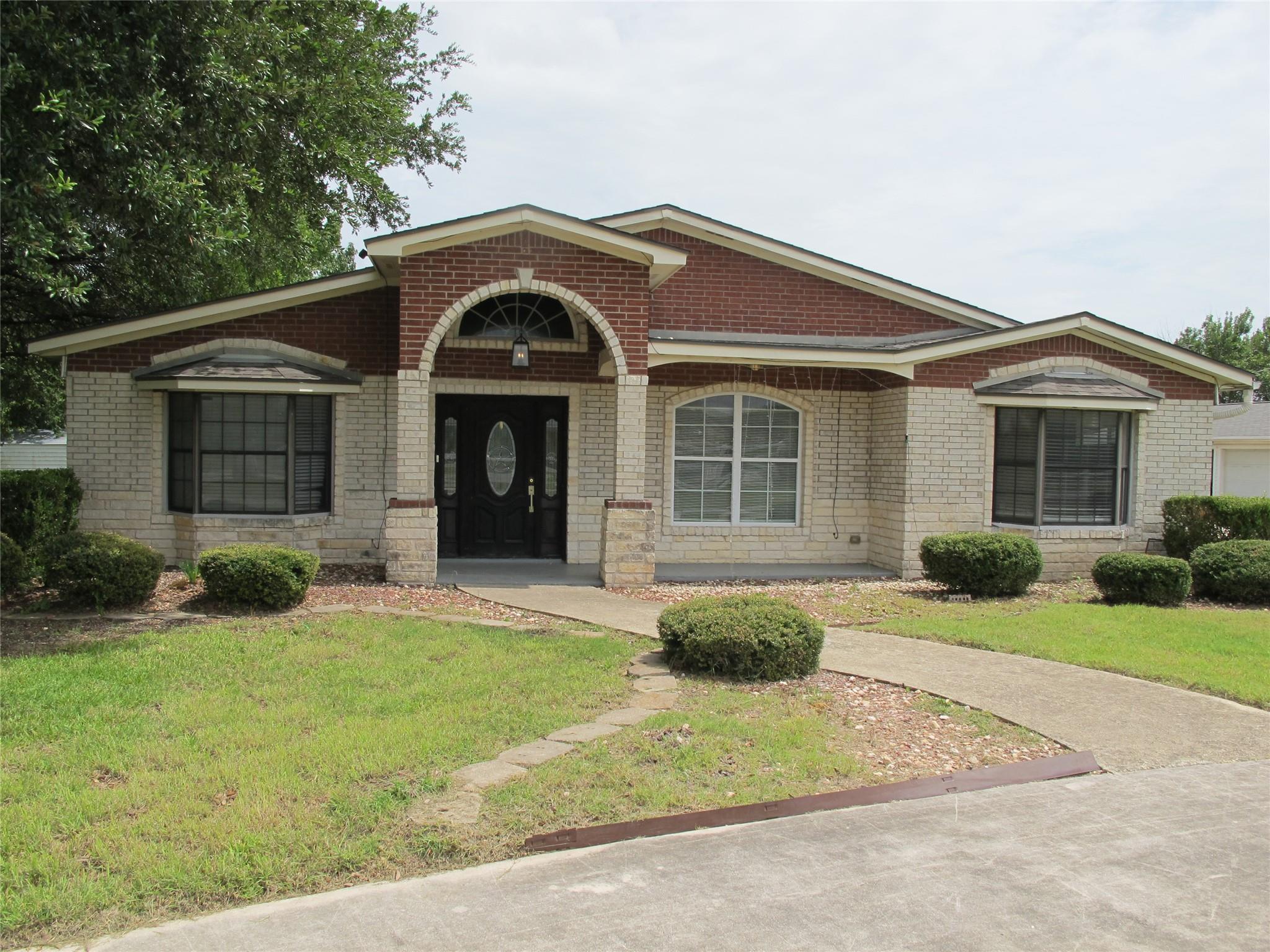 A charming brick and stone facade welcomes with a