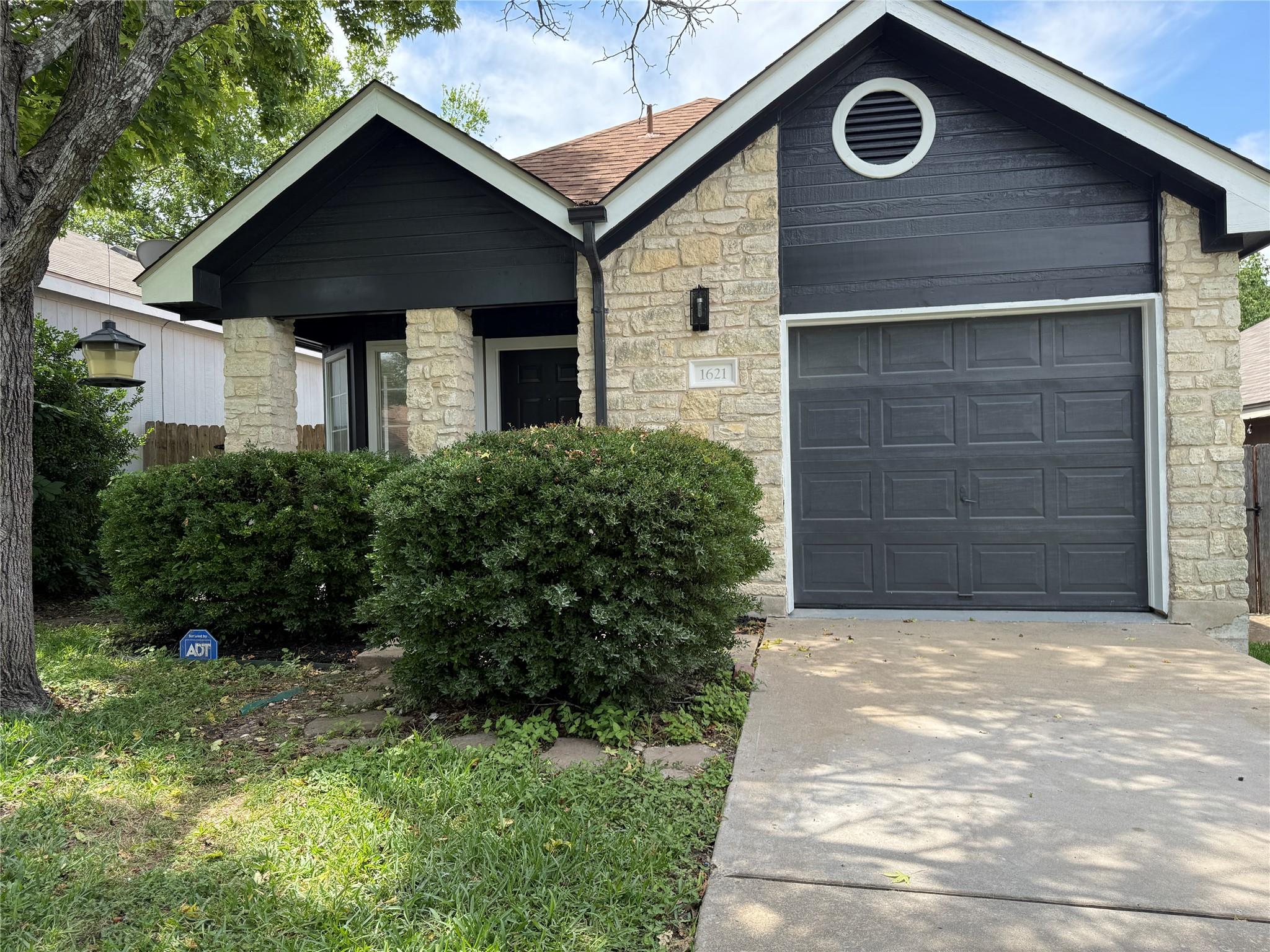A charming stone and dark siding facade welcomes 