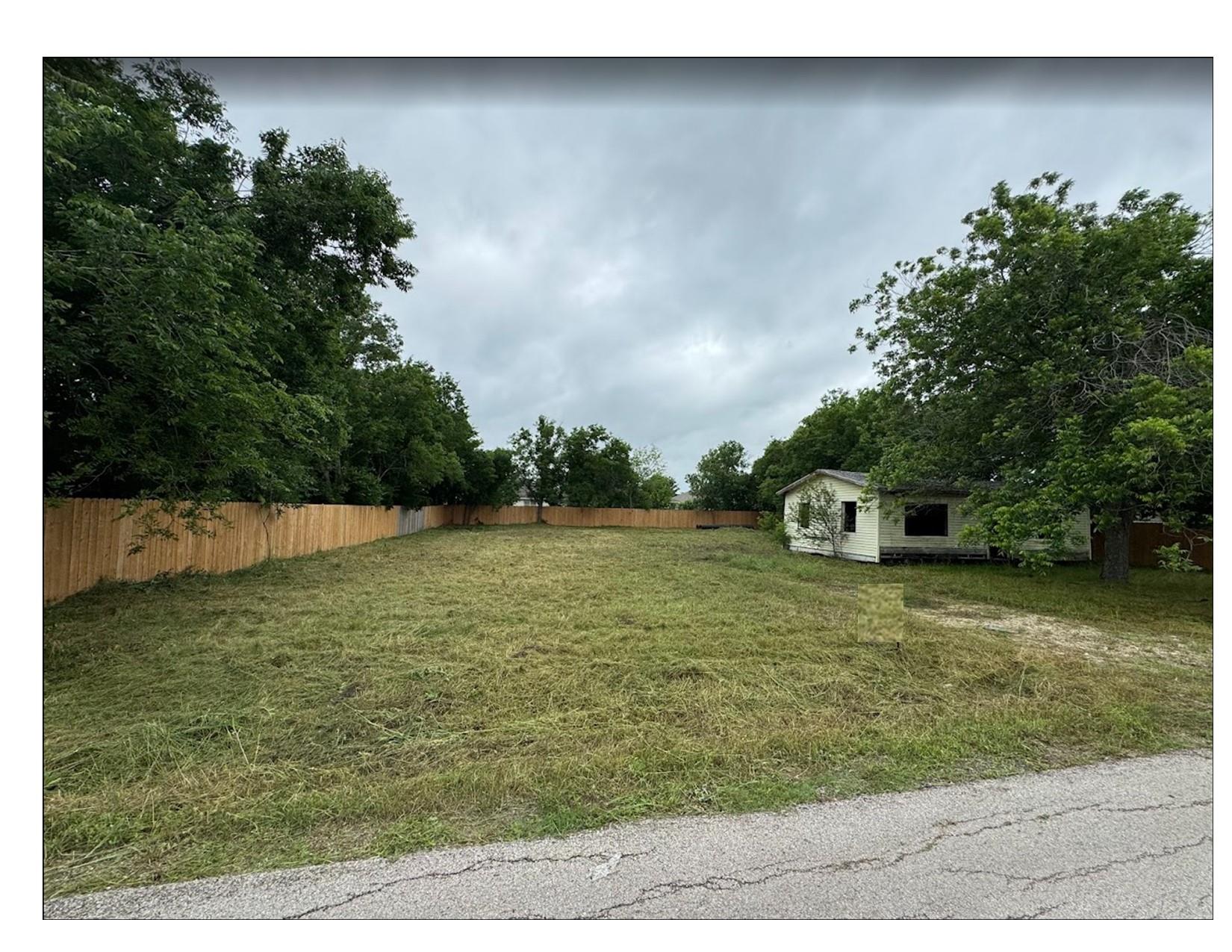 A cleared residential lot awaits development, bor
