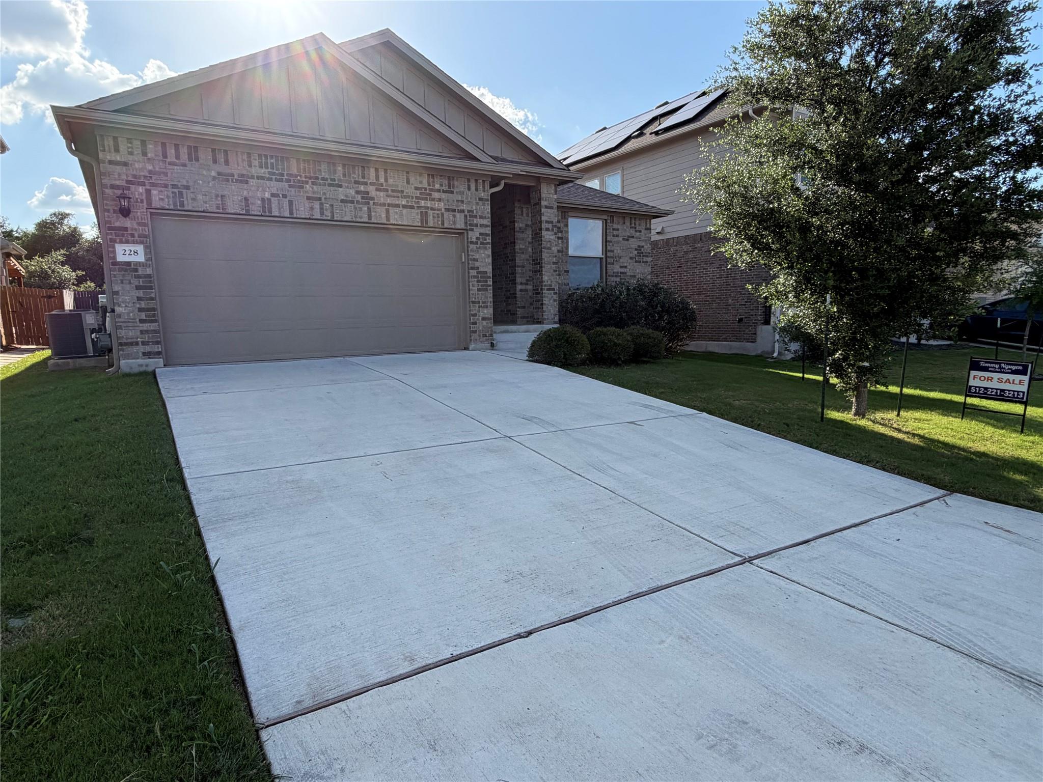 A welcoming brick exterior features a wide drivew
