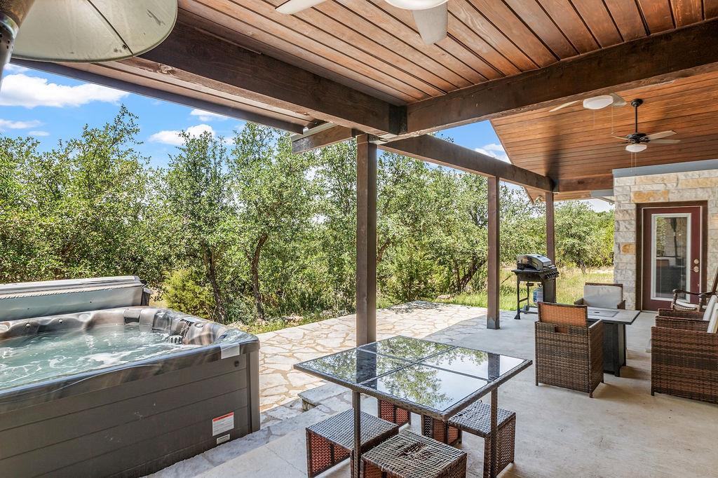 View of patio with a ceiling fan, a hot tub, and 
