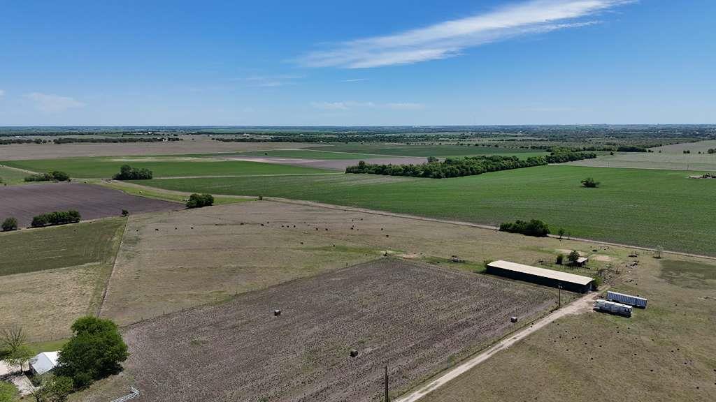 Vast farmland extends under a brilliant blue sky,