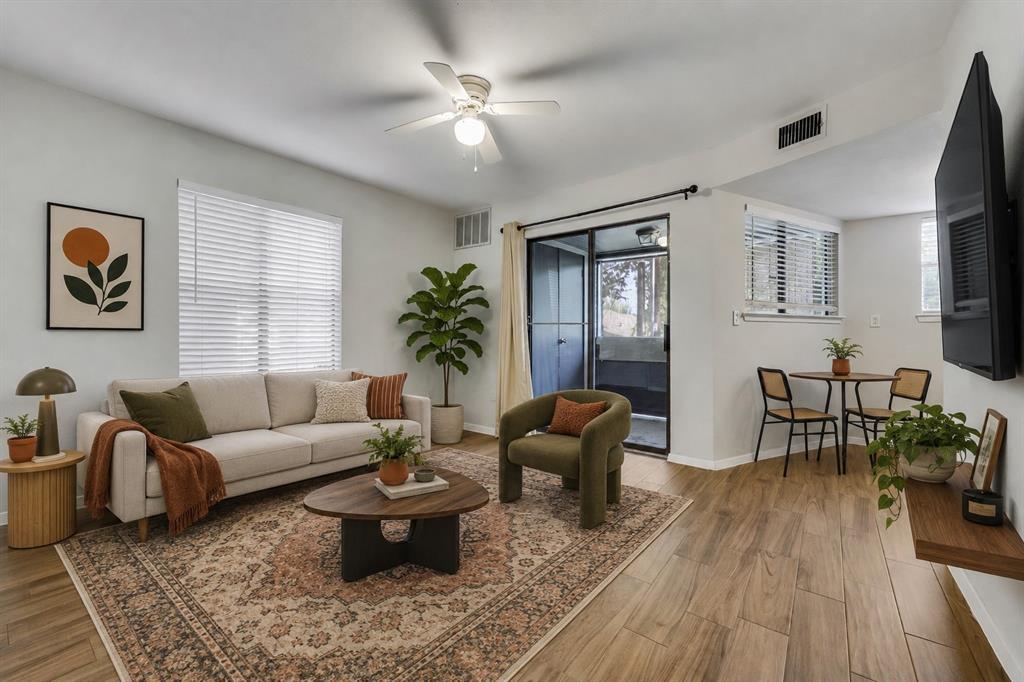 Warm wood-look flooring and glass doors to the ba