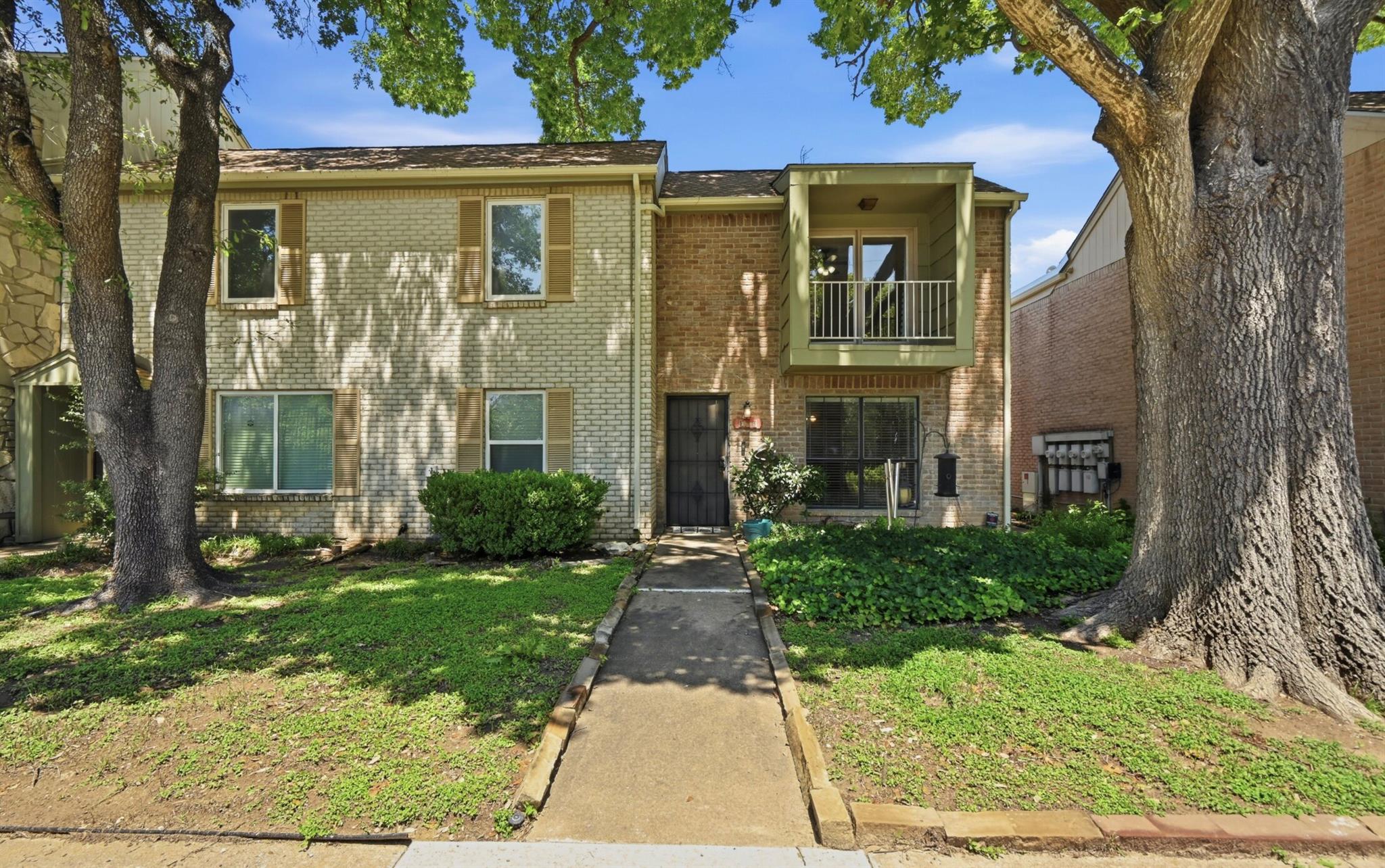Mature trees shade this two-story brick residence