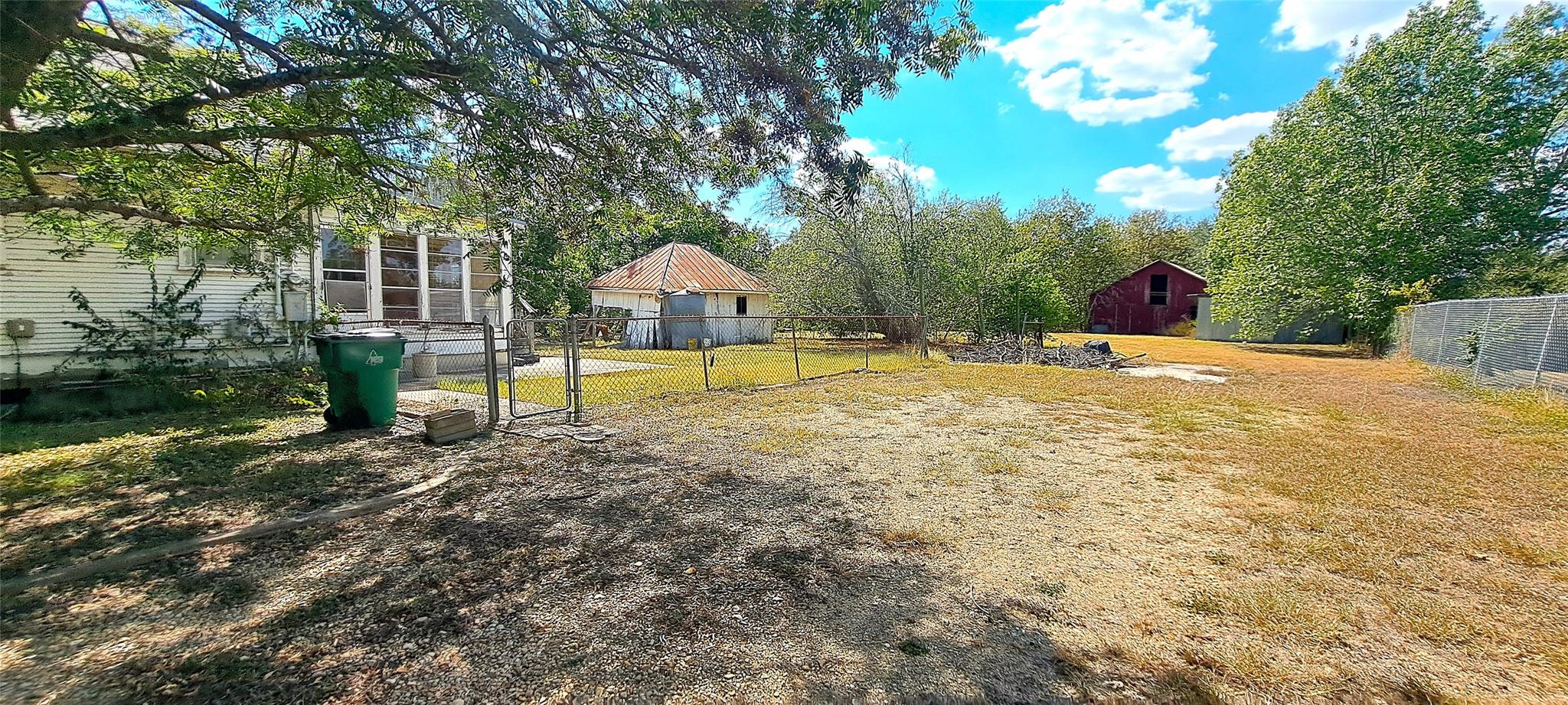 A spacious yard with varied terrain and fencing, 